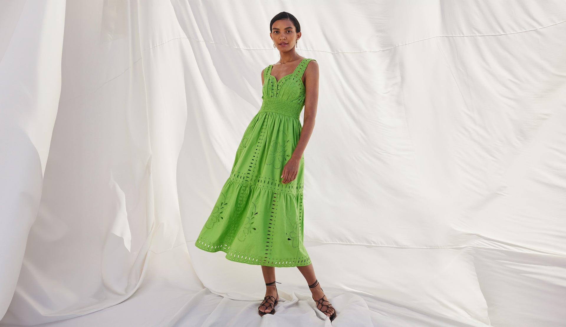 FRONT FULL BODY EDITORIAL IMAGE OF MODEL WEARING FAWN DRESS IN ISLAND GREEN