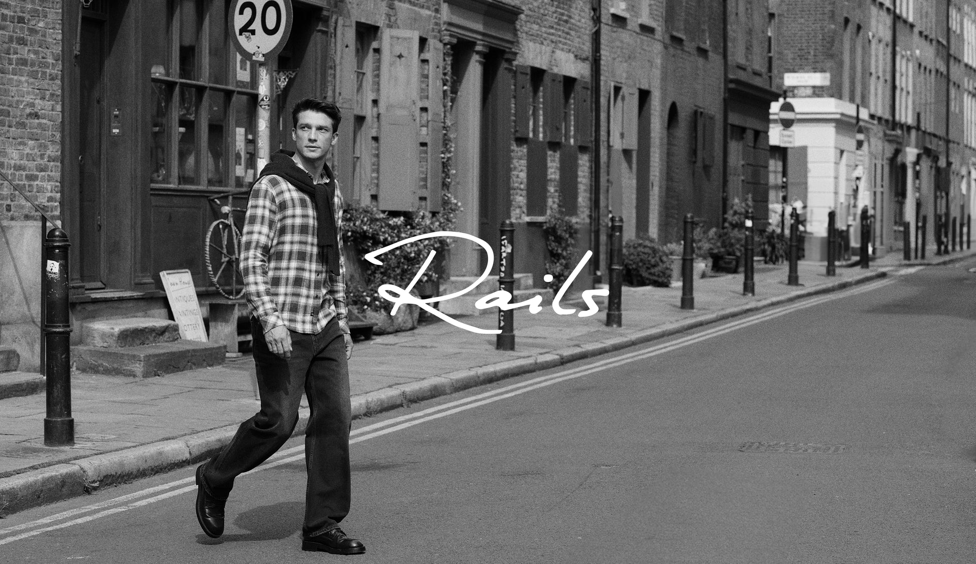 BLACK AND WHITE PHOTO OF MODEL WEARING LENNOX SHIRT AND CUTLER JEANS