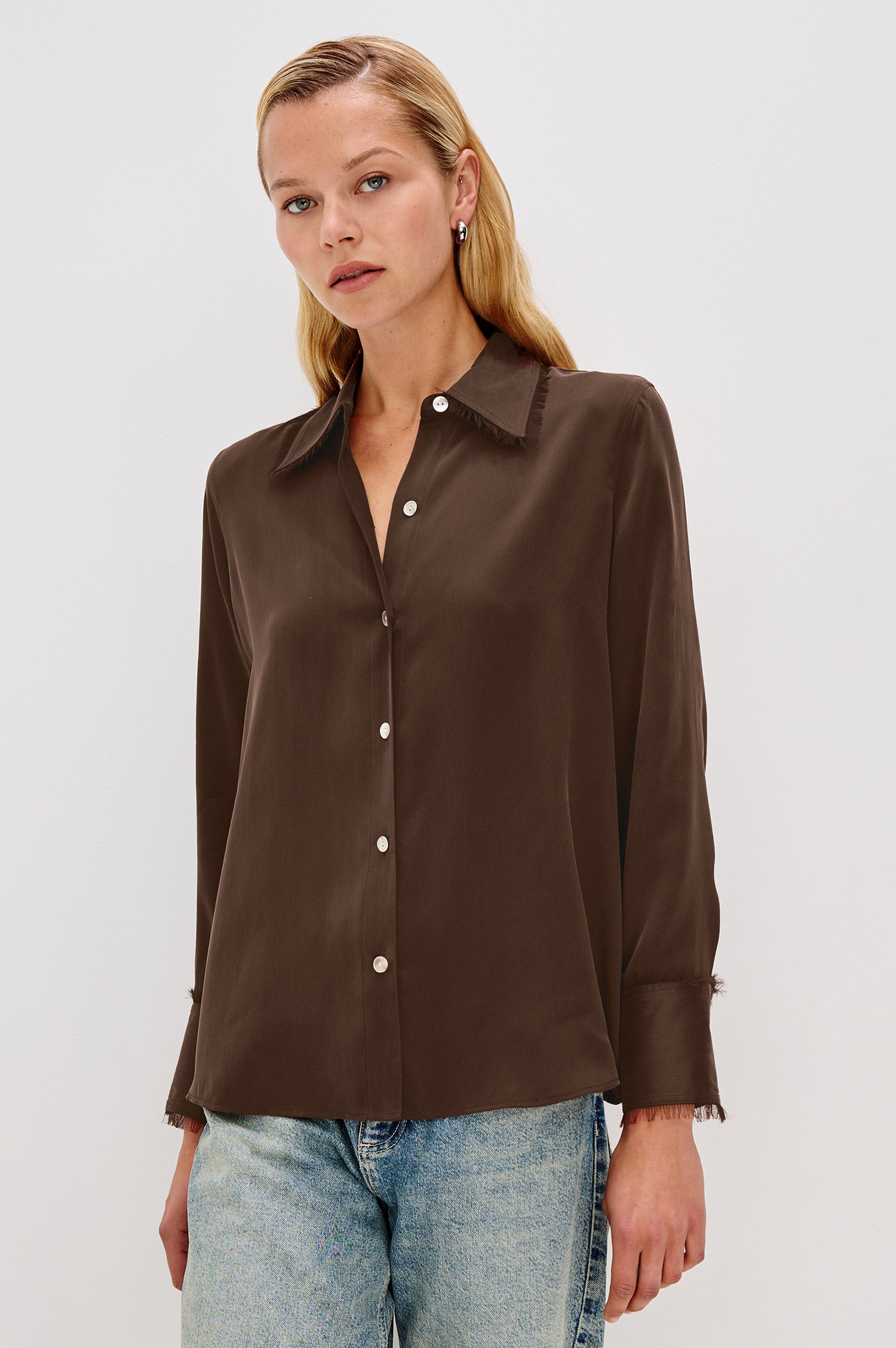 The Abbey is a silk charmeuse button-down shirt with raw edge detailing at the collar and cuffs, with a relaxed fit in Espresso Colorway - Front View Featured on Model, Untucked