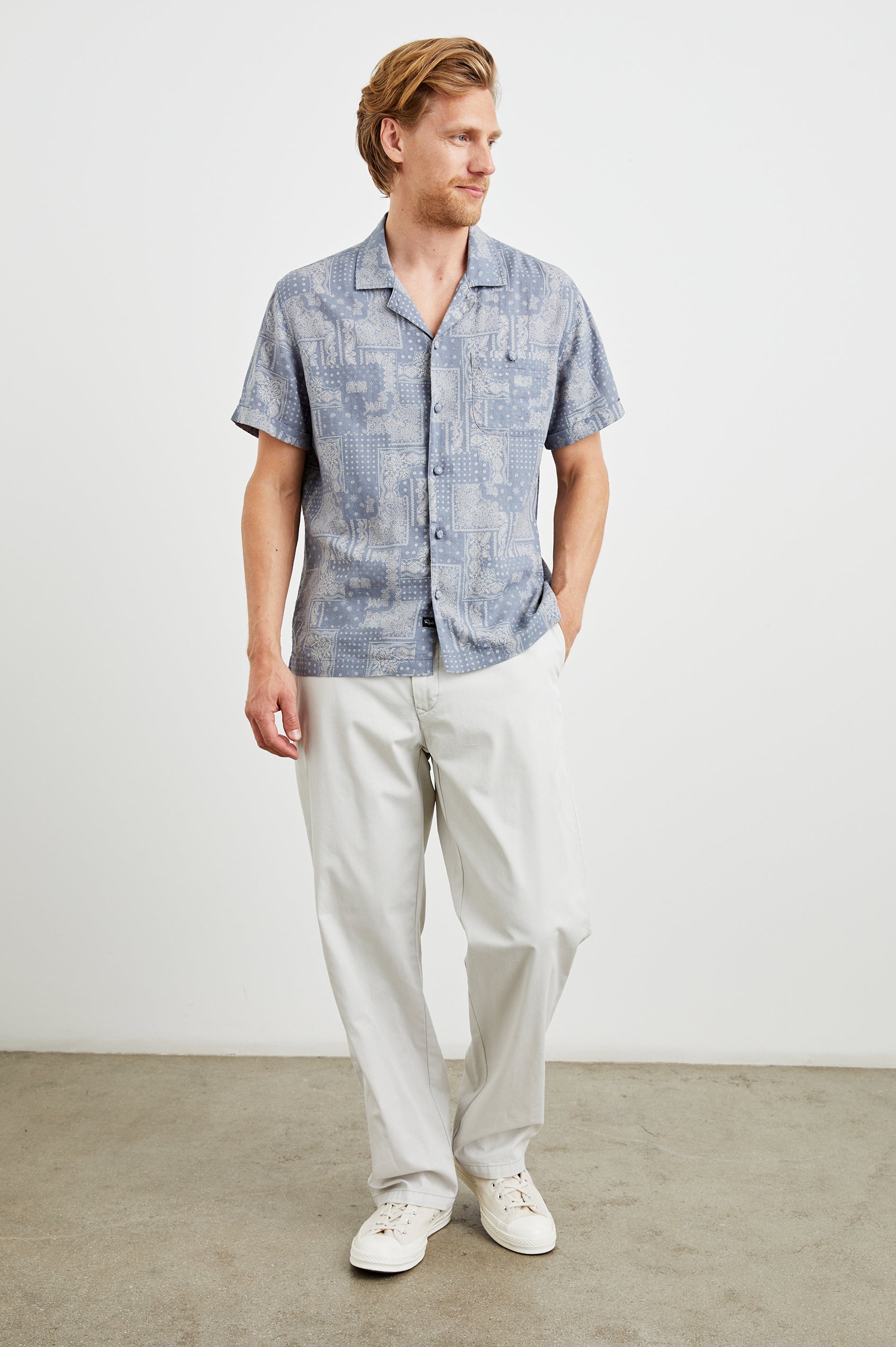 Ace Short Sleeve Button Up with Buttoned Chest Patch Pocket and Fabric Covered Buttons in Patchwork Bandana Slate Colorway, a design in Slate and Cream - Front Full Body View Featured on Model