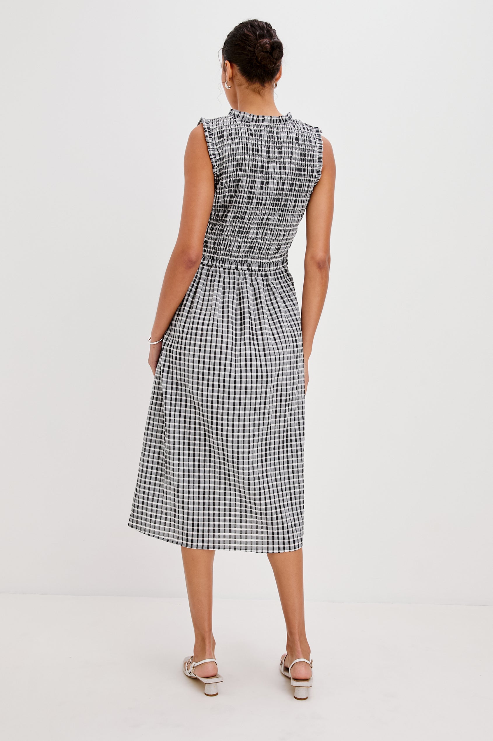 Adine Below-Knee Tank Dress with a Ruffle Edge V-Neck and Armhole, Tie Front, Gathered Bodice and A-Line Skirt in Ash Seersucker Colorway. Full Body Back View Shown on Model.