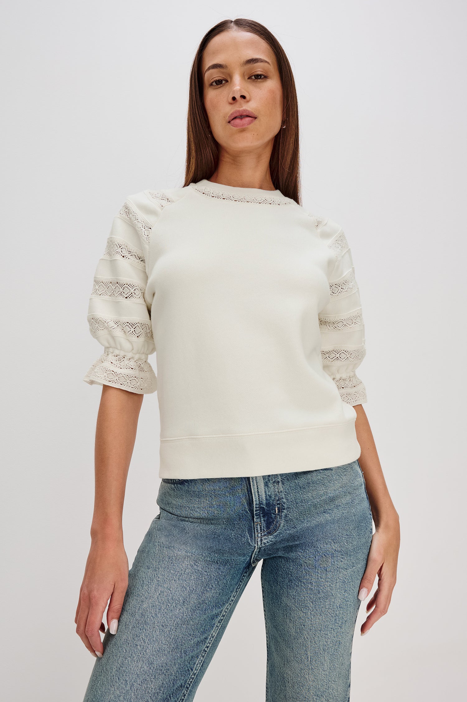 The Aggy is a raglan sleeve crew neck knit top, the sleeves are elbow length with an elastic lace cuff, there is lace inserts on sleeves and neck opening with a ribbed hem in Ivory colorway. Front View Featured on Model.