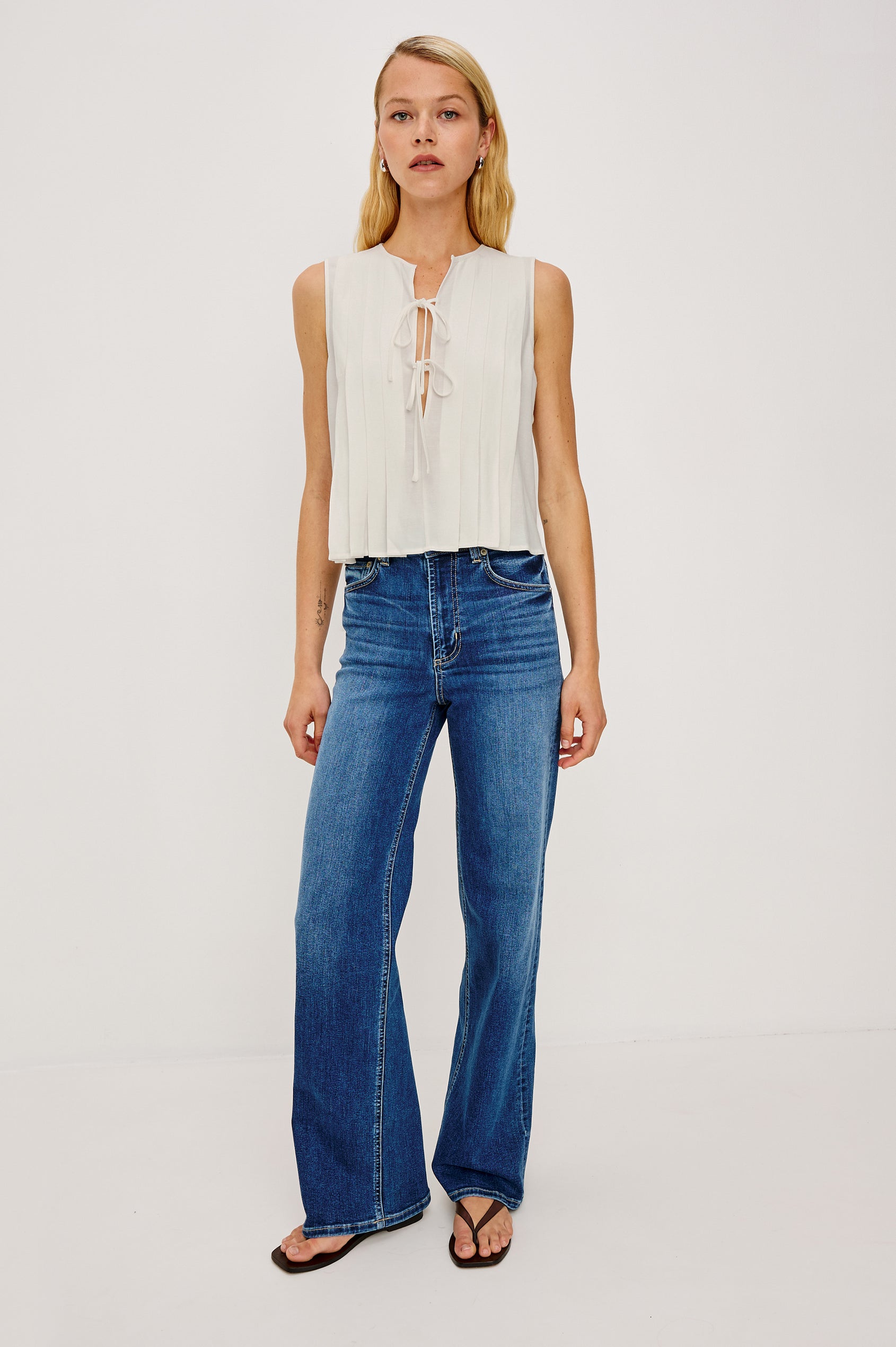 Aja Sleeveless Top in Linen With Plunging V-Neckline and Center-Front Ties and Front Pleats in Ivory Colorway - Full Body Front View Featured on Model