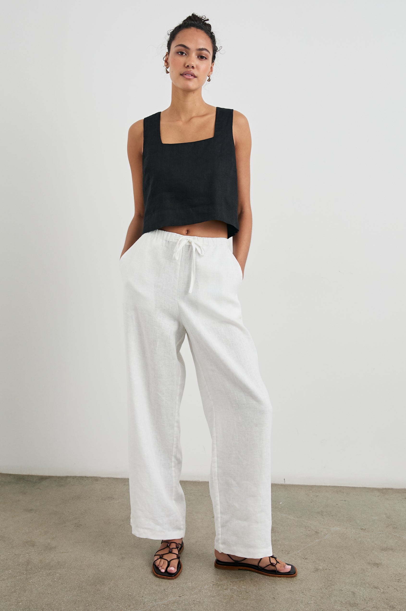 Akira Sleeveless Crop Top with Square Neckline and Wide Shoulder Straps in Black Colorway - Front Full Body View Featured on Model 