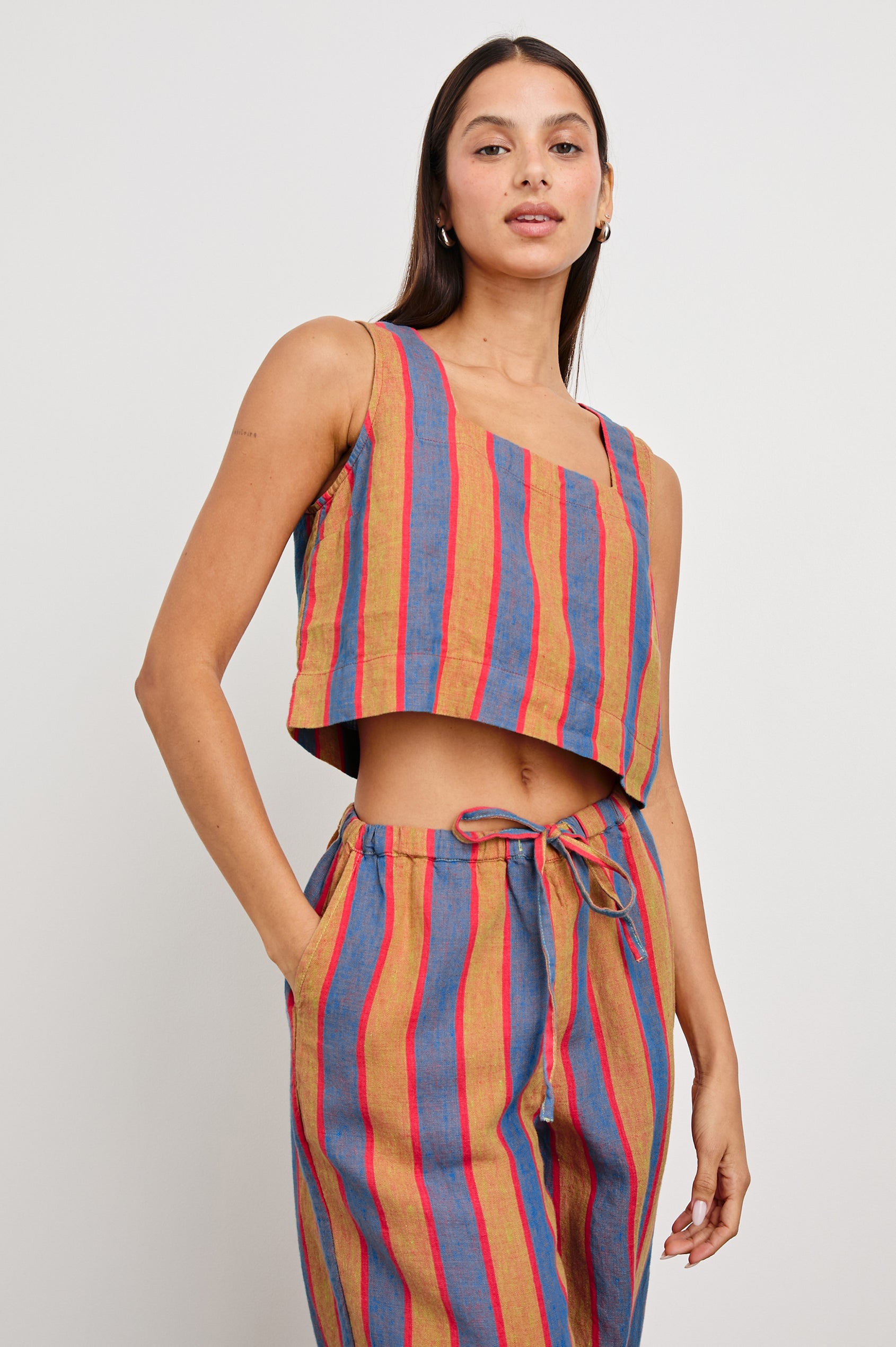 Akira Sleeveless Crop Top with Square Neckline and Wide Shoulder Straps in Rio Stripe Colorway, Vertical Stripes in Tan, Blue, and Pink - Front View Featured on Model 