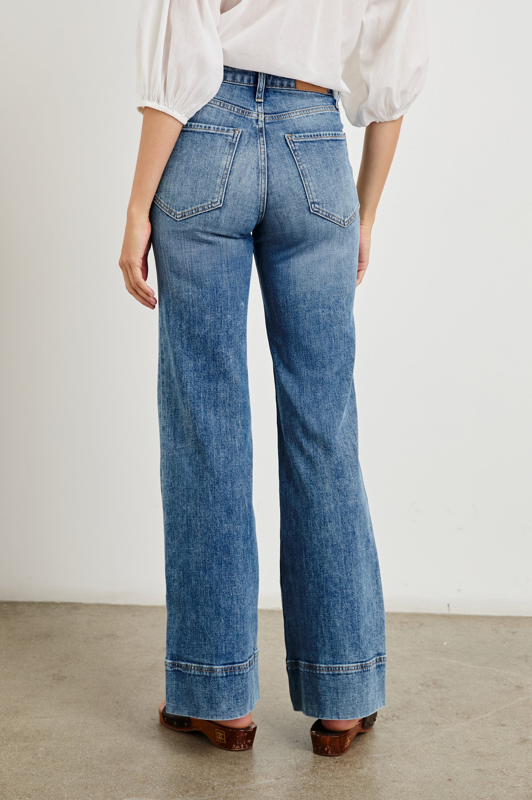Alamitos high waisted denim trouser with flared leg and front patch pockets in Tradewind - back view on model