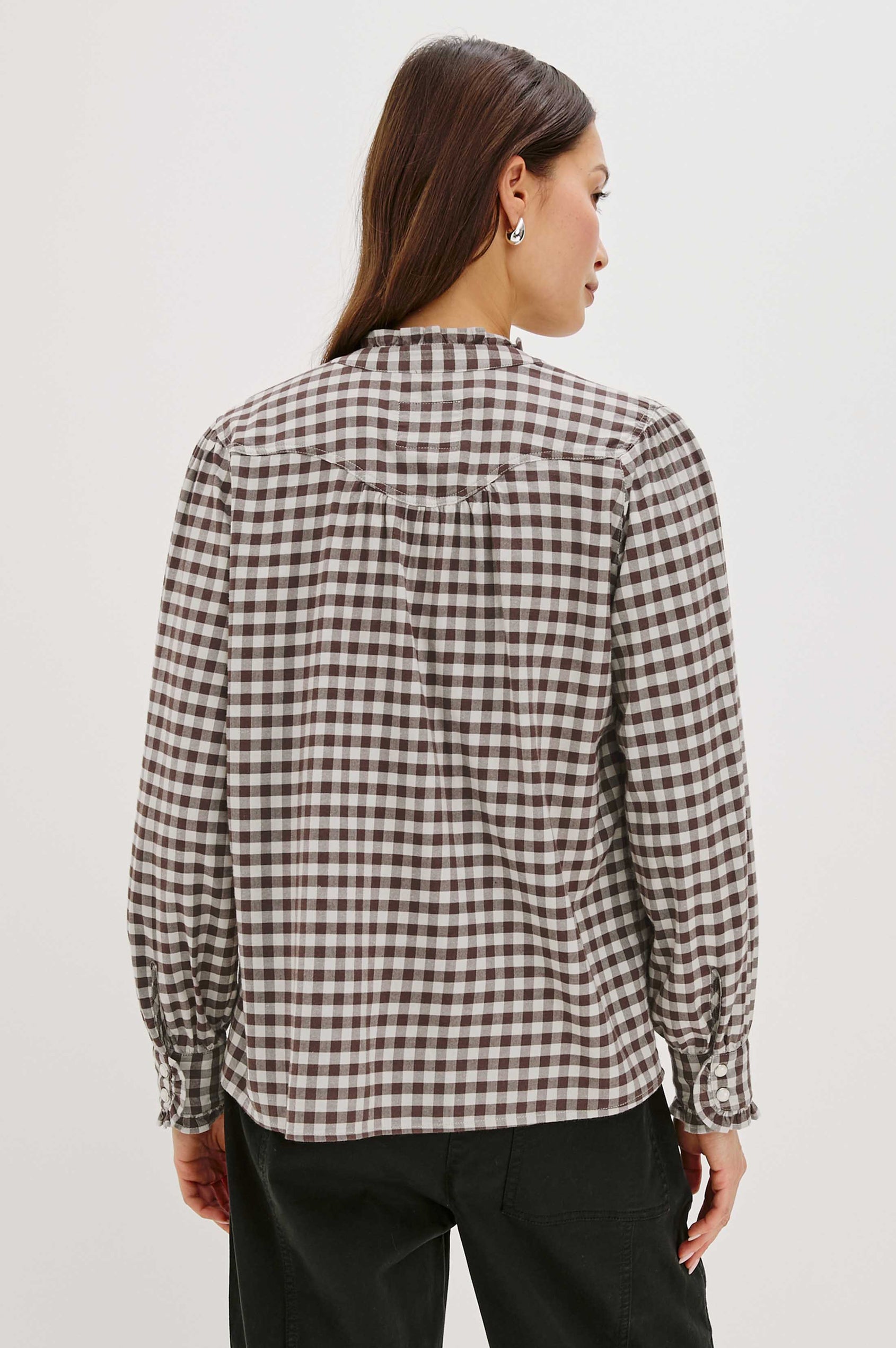 Woman wearing a black and white checkered shirt against a white background