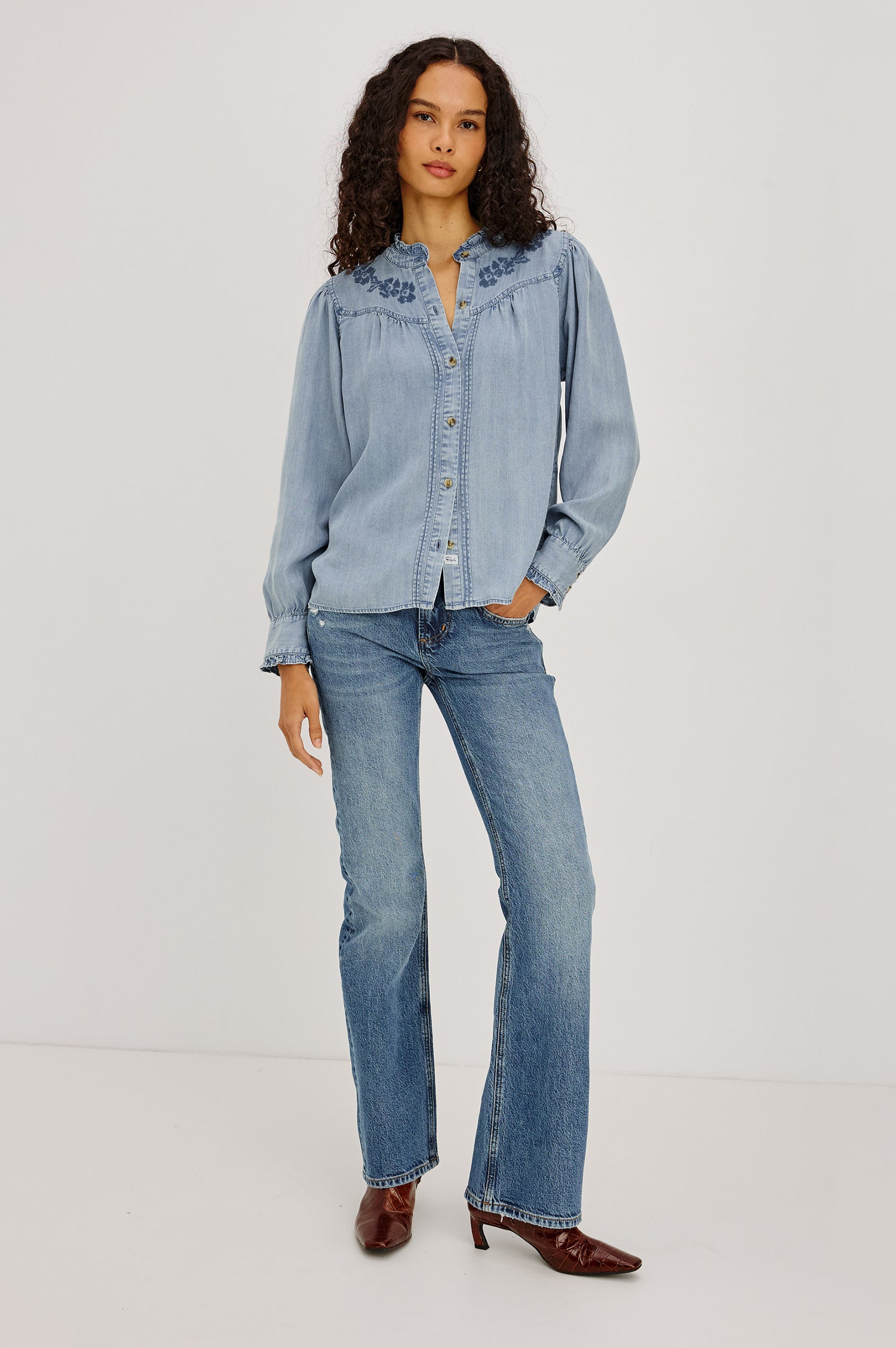 Alanna Shirt in TENCEL™ Denim With Front Buttons, Relaxed Fit, Pointelle Floral Embroidery, Long Sleeves, Curved Yoke, and Ruffle Trim in Medium Cloud Wash Colorway - Full Body Front View Featured on Model