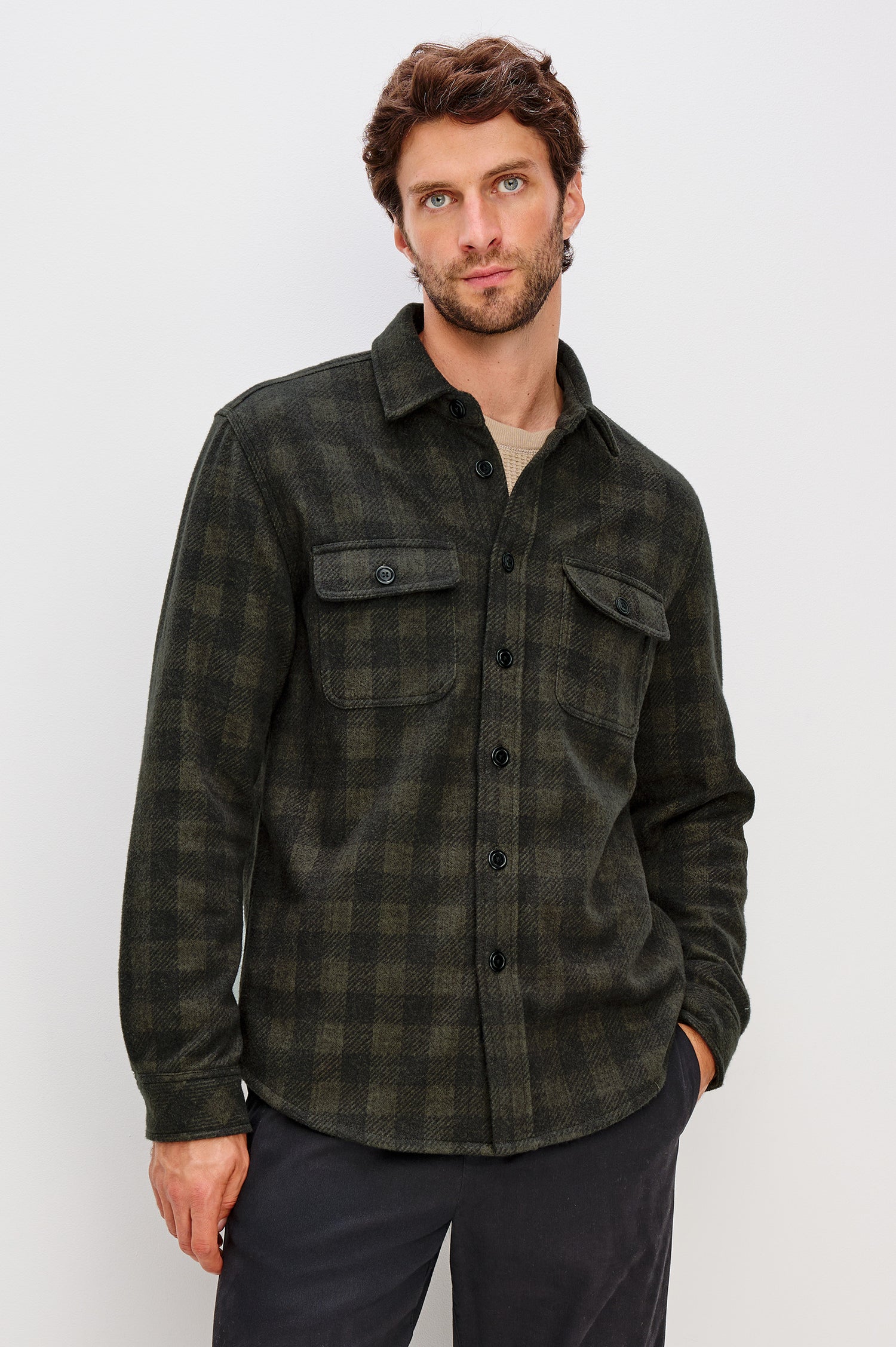 Alder Long-Sleeve Button up with Two Buttoned Chest Flap Pockets in Onyx Surplus Colorway, a Green and Black plaid. Front View Featured on Model