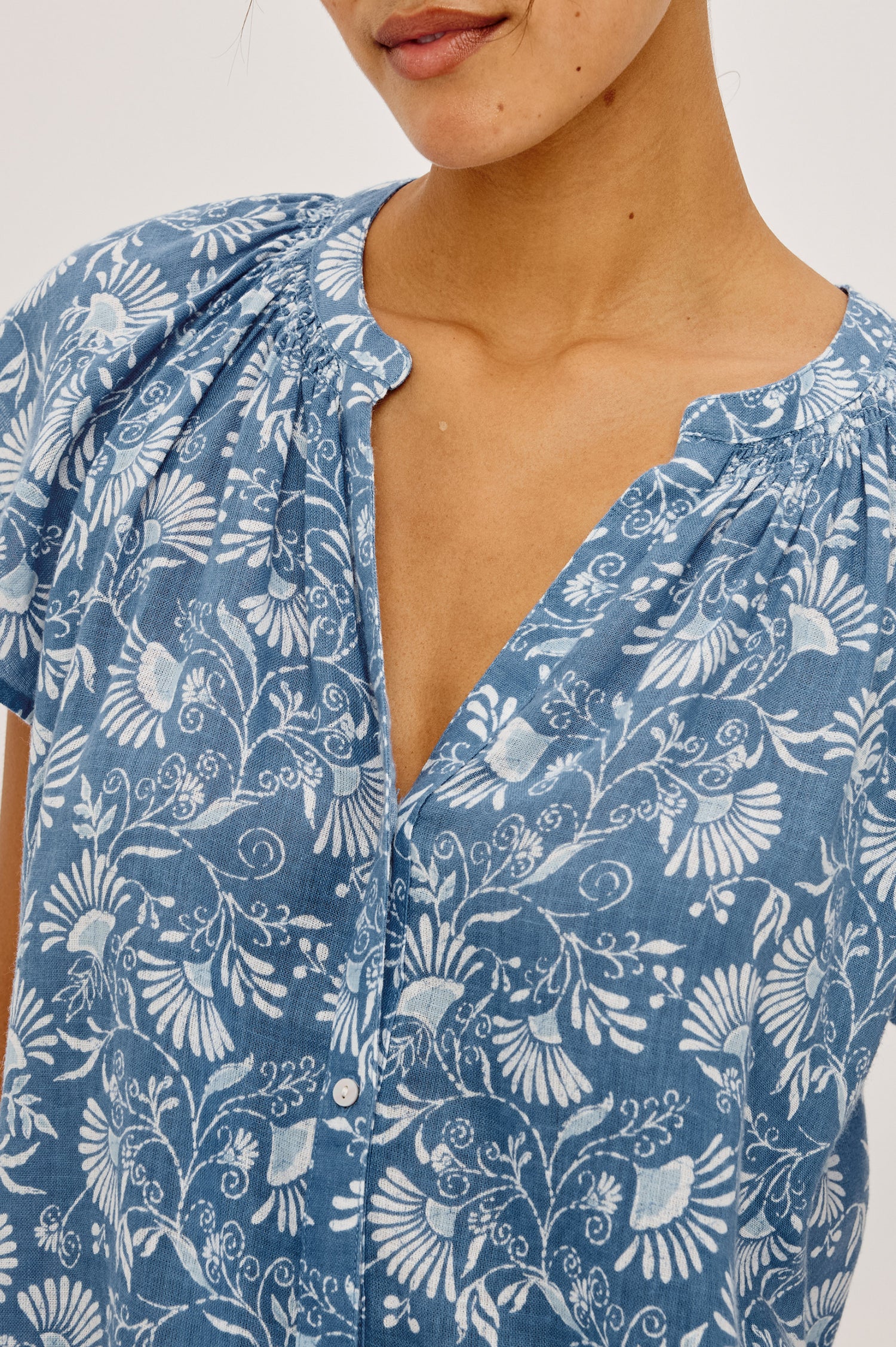Alena Top in Cotton Gauze With Relaxed Fit, Smocked Split Neckline, Cap Sleeves, and Front Button Placket in Blue Cassia Colorway - Upper Body Close Up View Featured on Model