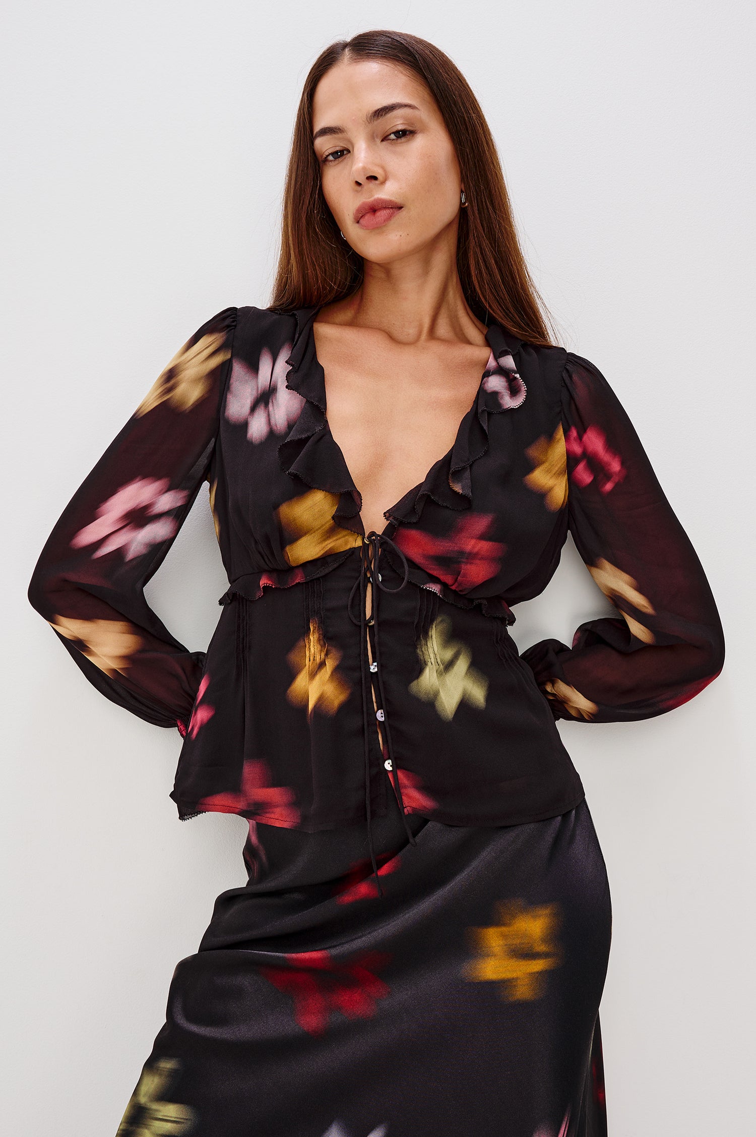 Alixa Blouse in Chiffon With Ruffled Deep V-Neckline, Front Buttons, and Long Balloon Sleeves With Smocked Bell Cuffs in Blurred Floral Colorway - Upper Body Front View Featured on Model