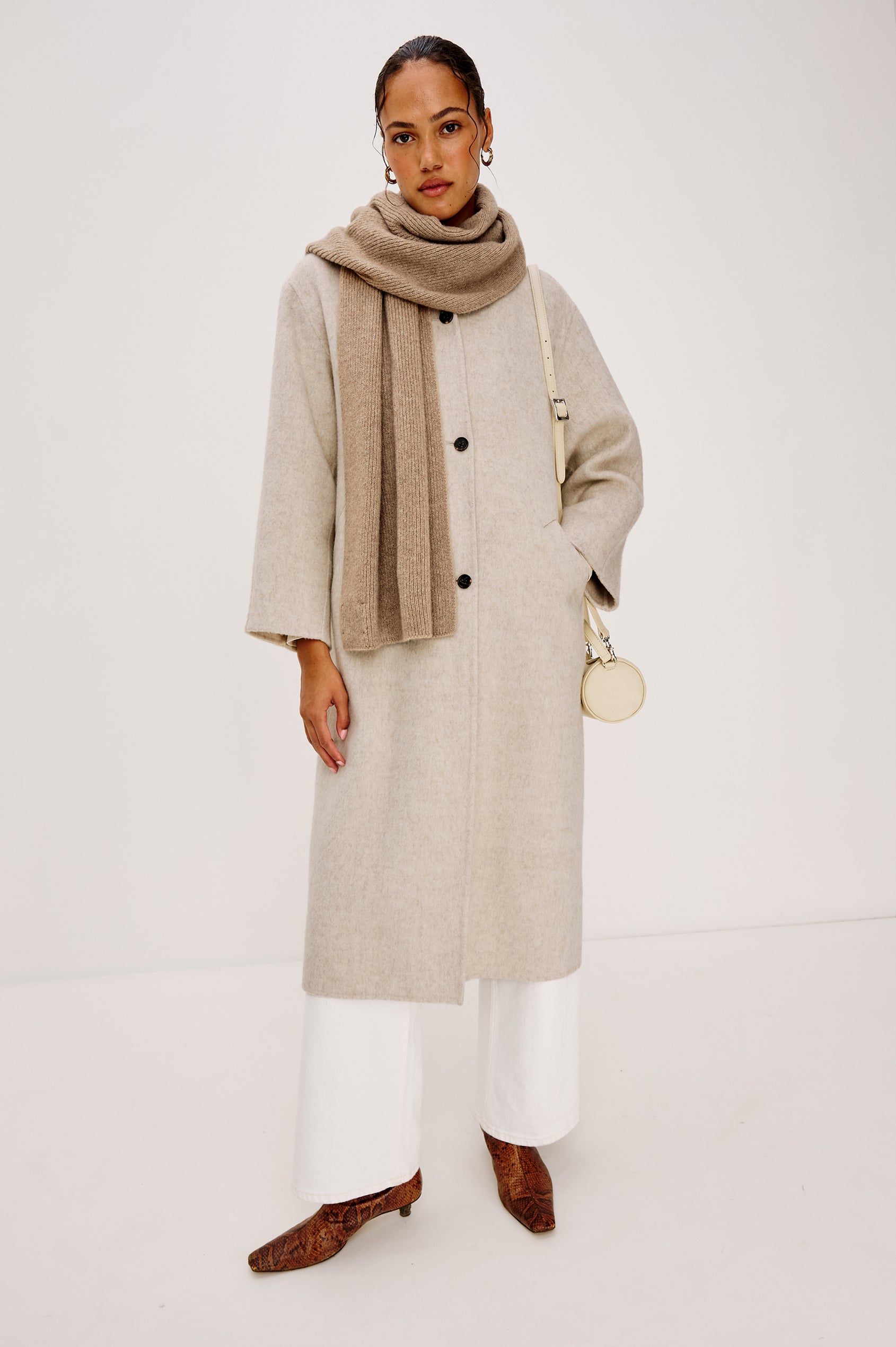 Alps is a cashmere scarf in Oat colorway. Front full body view featured on model.