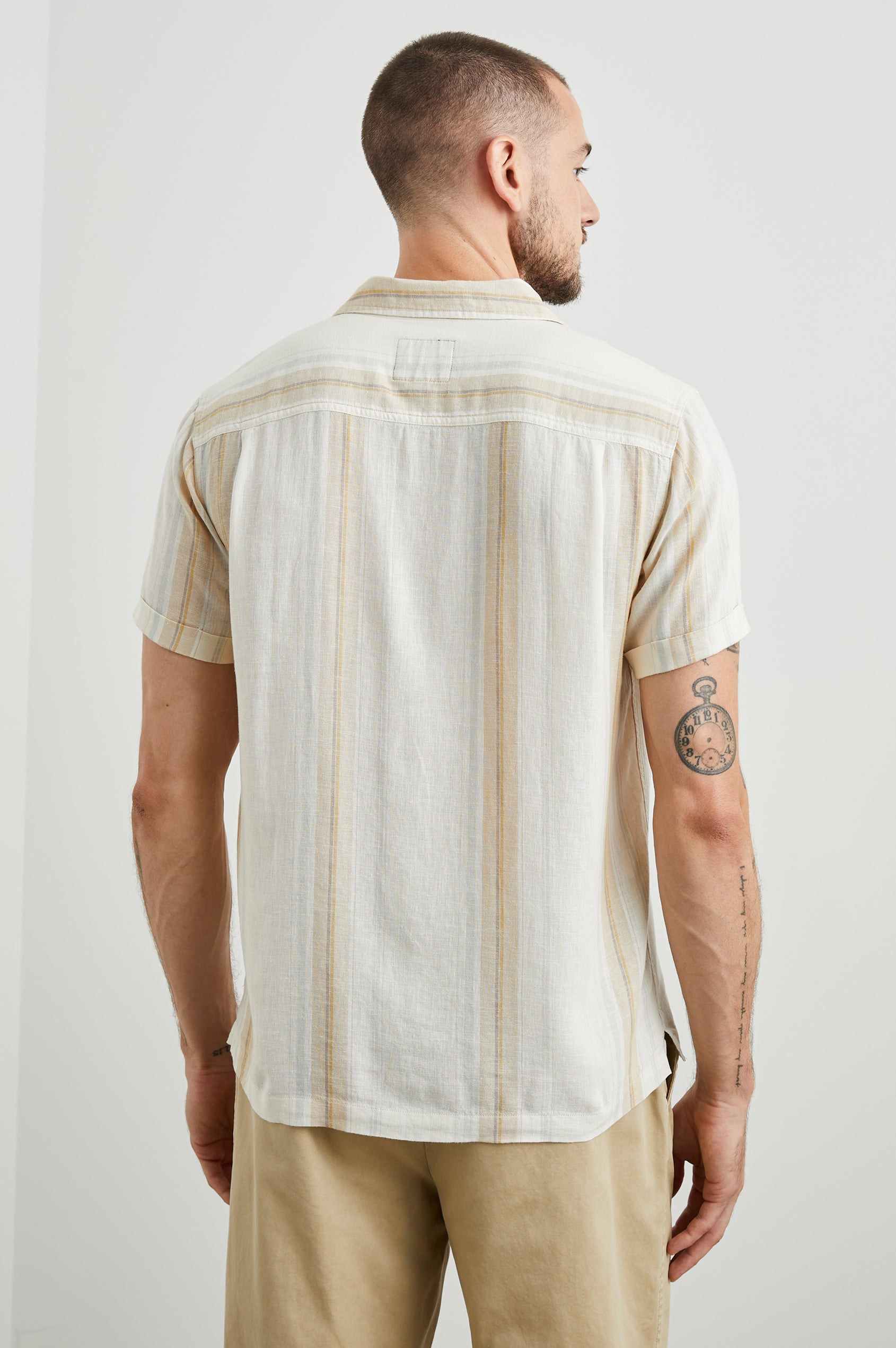Amalfi Short-Sleeve Button Up in Farro Dove Stripe Colorway, vertical stripes in faro and pale oranges on Dove - Back View Featured on Model