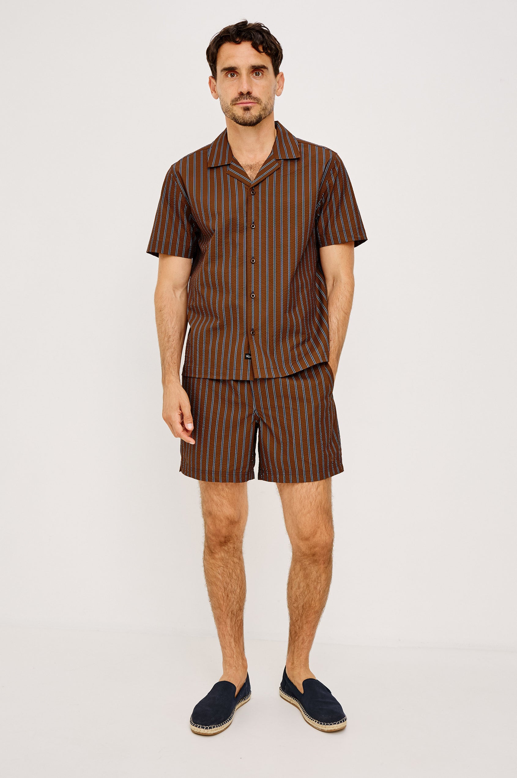 Amalfi Camp Shirt in Lightweight Seersucker With Notched Collar, Front Buttons, Short Sleeves, and Relaxed Fit in Rust Navy Stripe Colorway - Full Body Front View Featured on Model