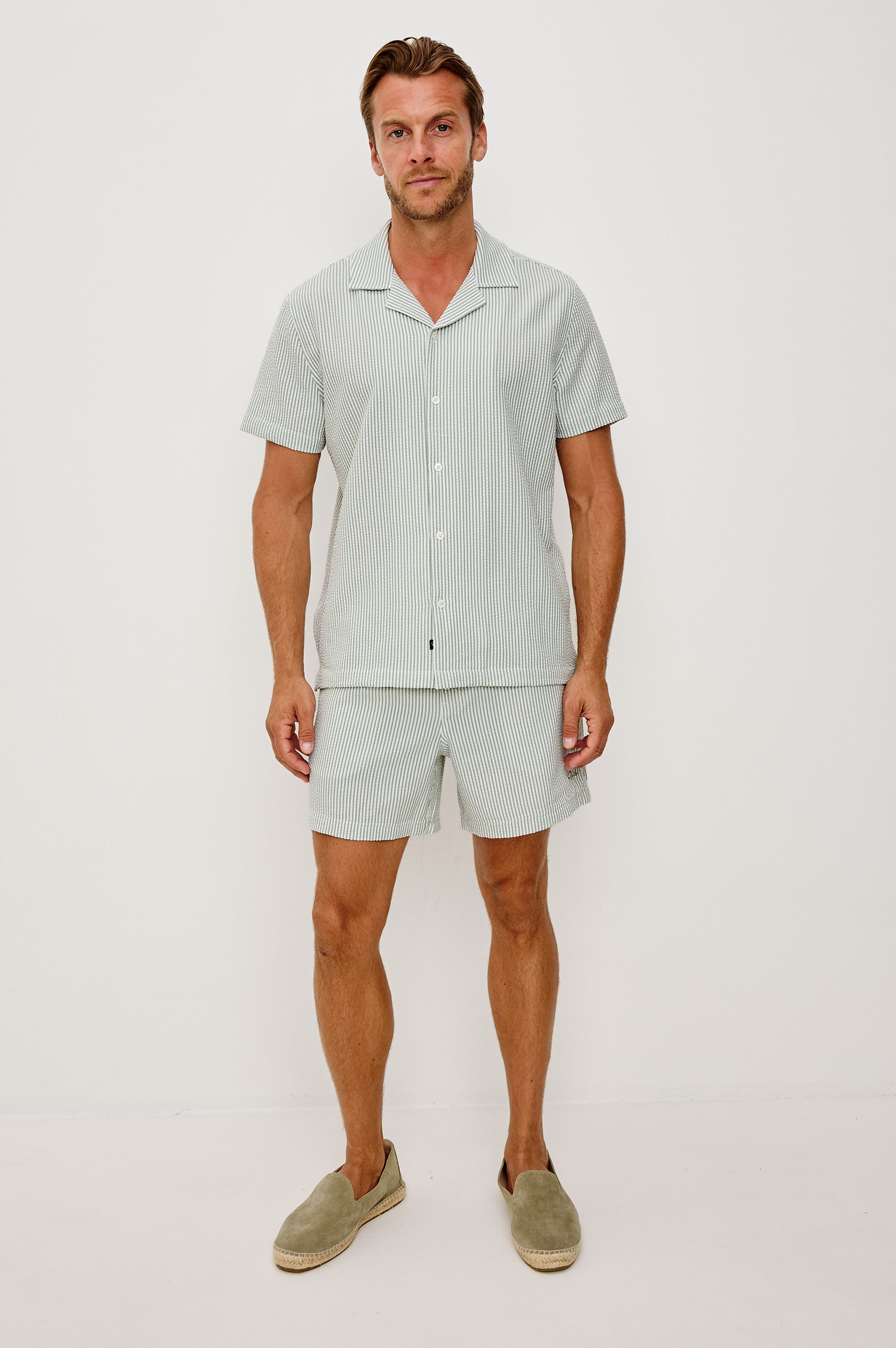 The Amalfi Button-Up Short Sleeve Shirt in Lightweight Stretch Linen-Blend With a Notched Collar and Classic Fit in Sage White Seersucker - Full Body Front View Featured on Model