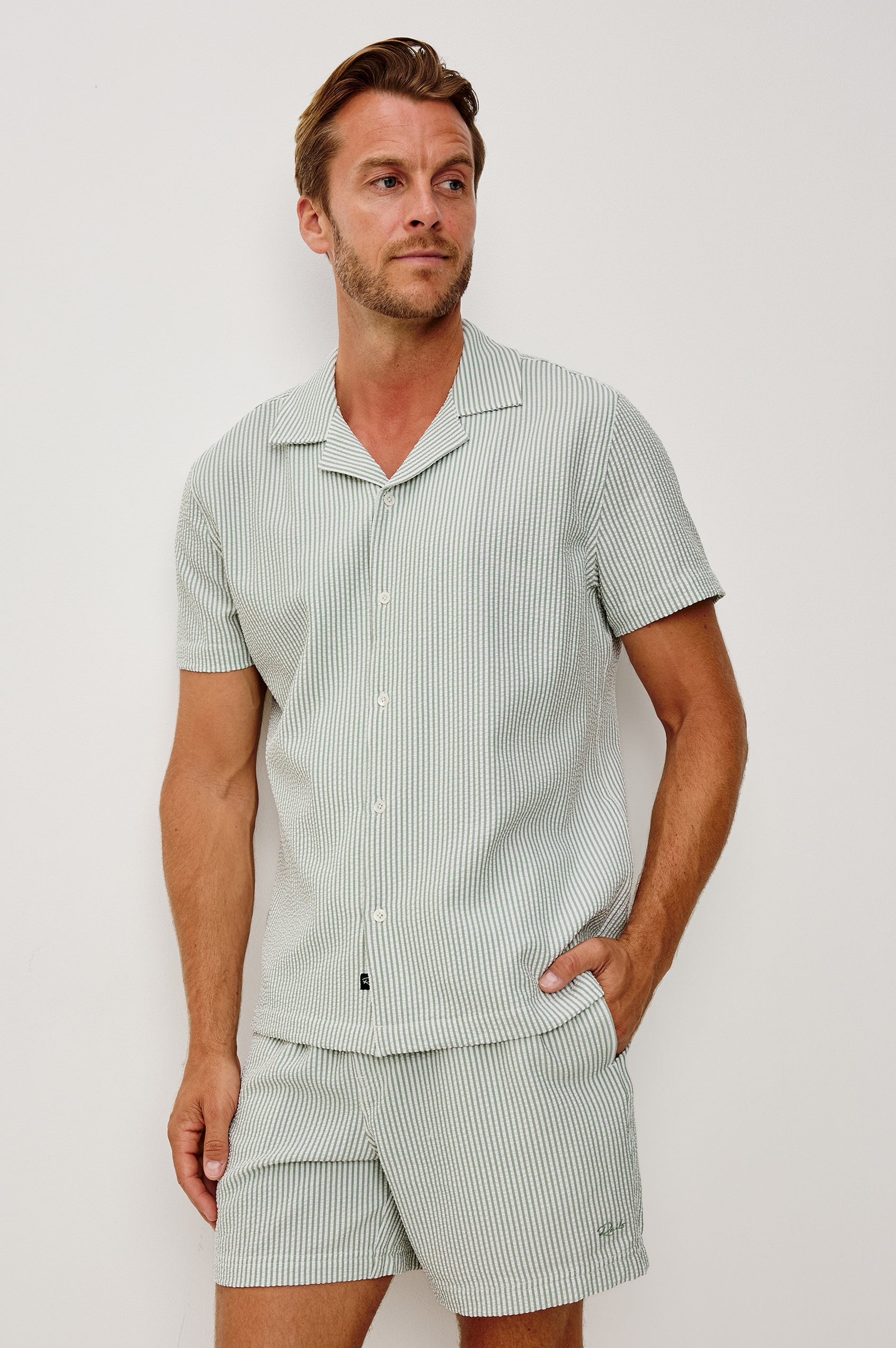 The Amalfi Button-Up Short Sleeve Shirt in Lightweight Stretch Linen-Blend With a Notched Collar and Classic Fit in Sage White Seersucker - Upper Body Front View Featured on Model
