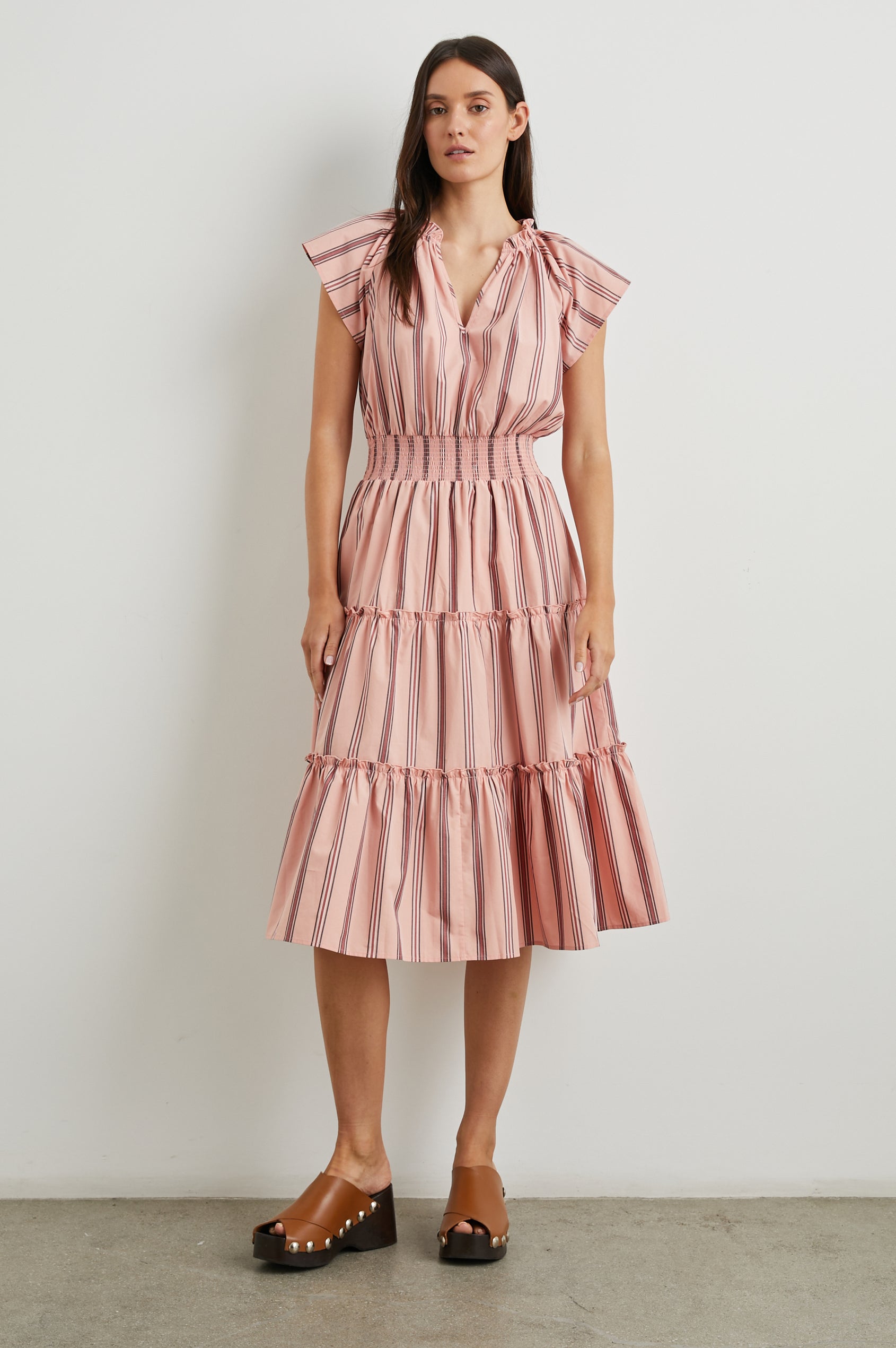 Amellia Short-Sleeve Midi Dress with Smocked Waist and Collar, V Neck, and a Tiered Skirt in Coral Navy Stripe Colorway, Vertical Coral and Navy Stripes on Peach - Front Full Body View Featured on Model