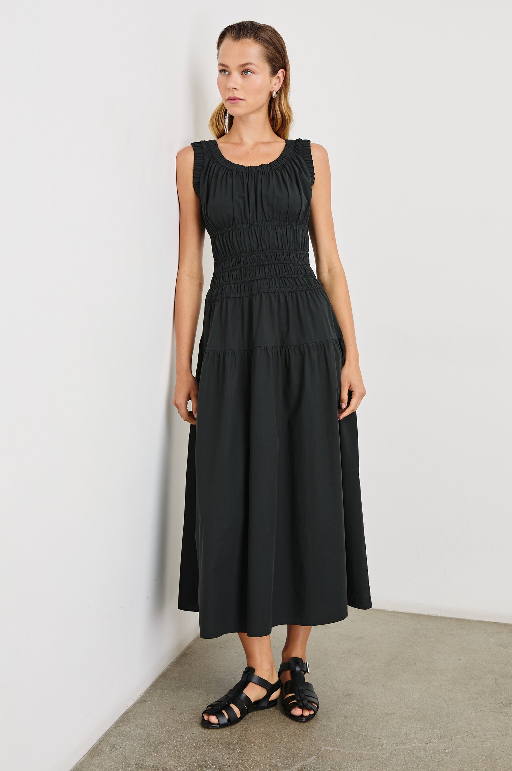 Anastasia Sleeveless Tiered Midi Dress with Shoulder Straps, a Scoop Neck and Ruching on the Bodice in Black Colorway - Front Full Body View Featured on Model  