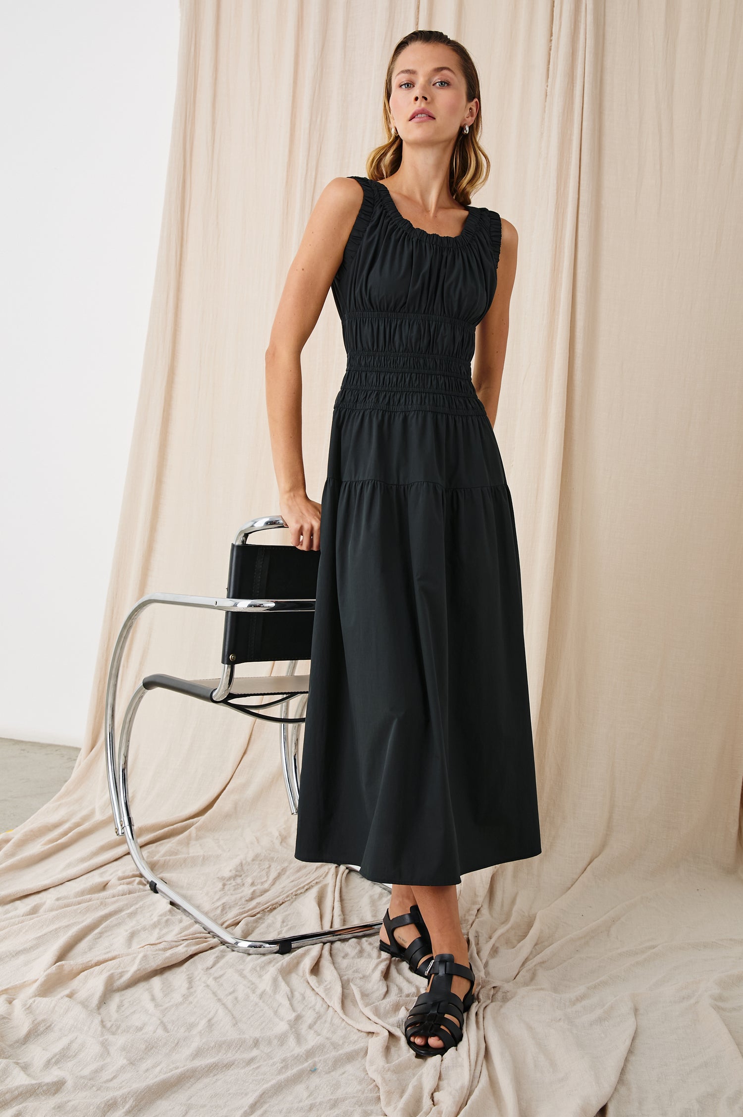 Anastasia Sleeveless Tiered Midi Dress with Shoulder Straps, a Scoop Neck and Ruching on the Bodice in Black Colorway - Front Full Body View Featured on Model  