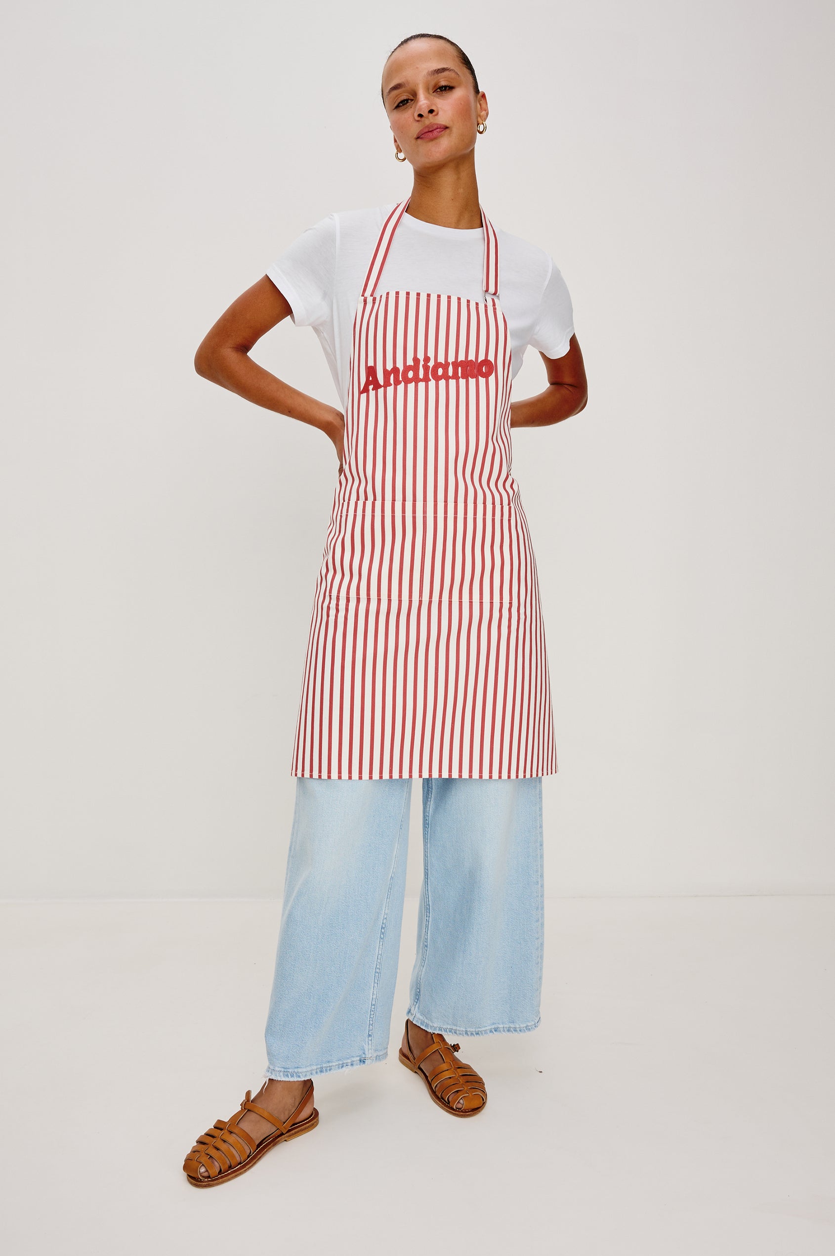 Andiamo Apron in Ravello Stripe with adjustable neck straps, dual front pockets and 'Andiamo' expression on the chest. Front view on model