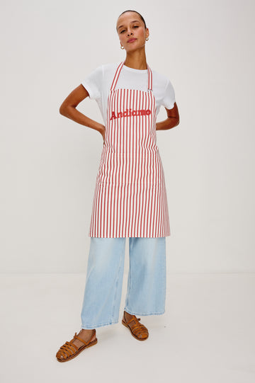 Andiamo Apron in Ravello Stripe with adjustable neck straps, dual front pockets and 'Andiamo' expression on the chest. Front view on model