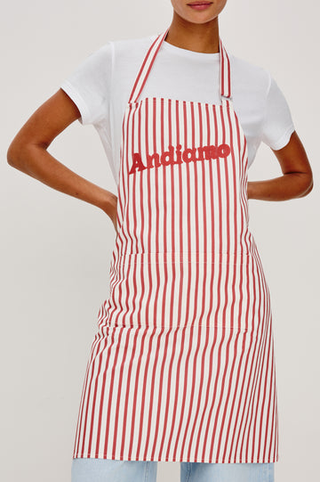 Andiamo Apron in Ravello Stripe with adjustable neck straps, dual front pockets and 'Andiamo' expression on the chest. Close up view on model