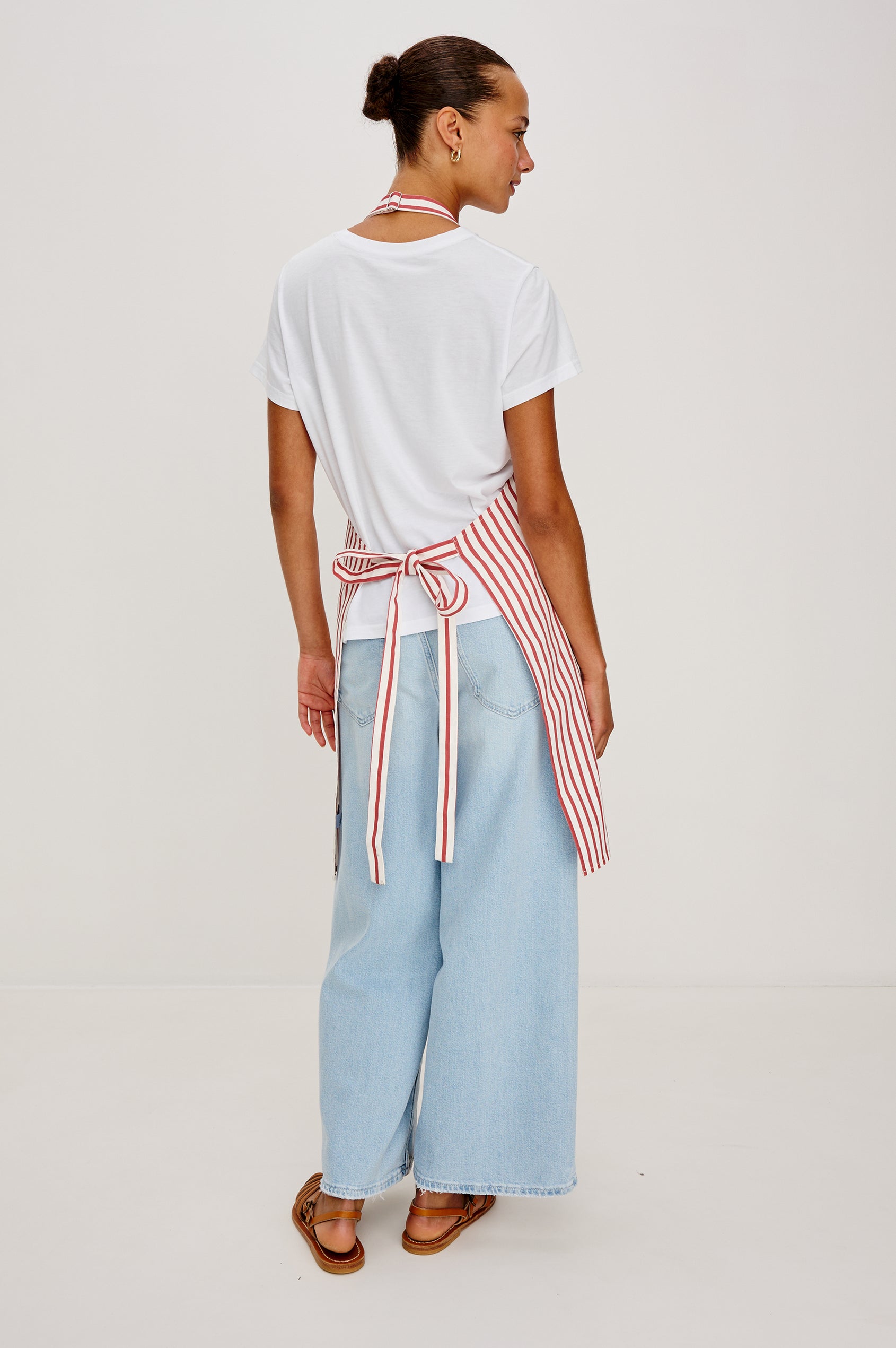 Andiamo Apron in Ravello Stripe with adjustable neck straps, dual front pockets and 'Andiamo' expression on the chest. Back view on model