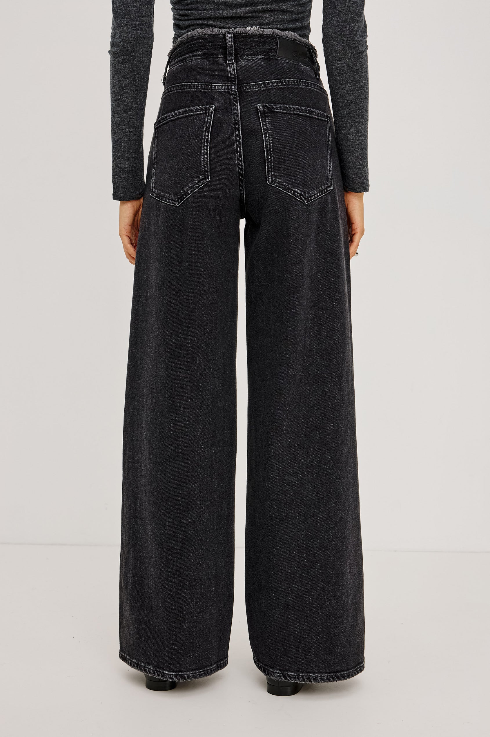 Angeleno Wide Leg in Rigid Denim With Hidden Stretch, Relaxed Mid-Rise Fit, 5-Pockets, Self-Tie Shoelace Belt, and Frayed Waistband in Ash Black Colorway - Lower Body Back View Featured on Model