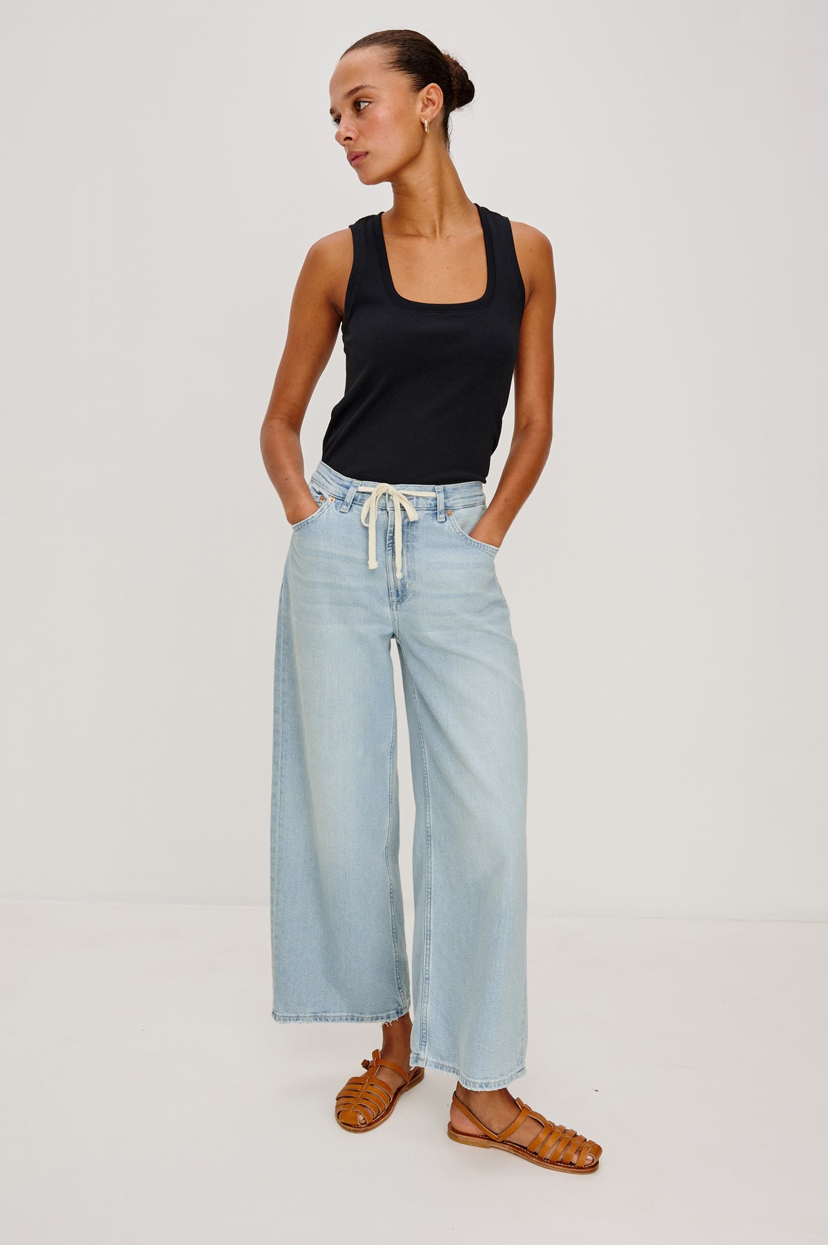 Angeleno Crop Denim Pant, Wide Leg, Five Pocket Zip Fly with a White Drawstring Tie at Waist in Light Wash Scuba Colorway. Front full body View Shown on Model.