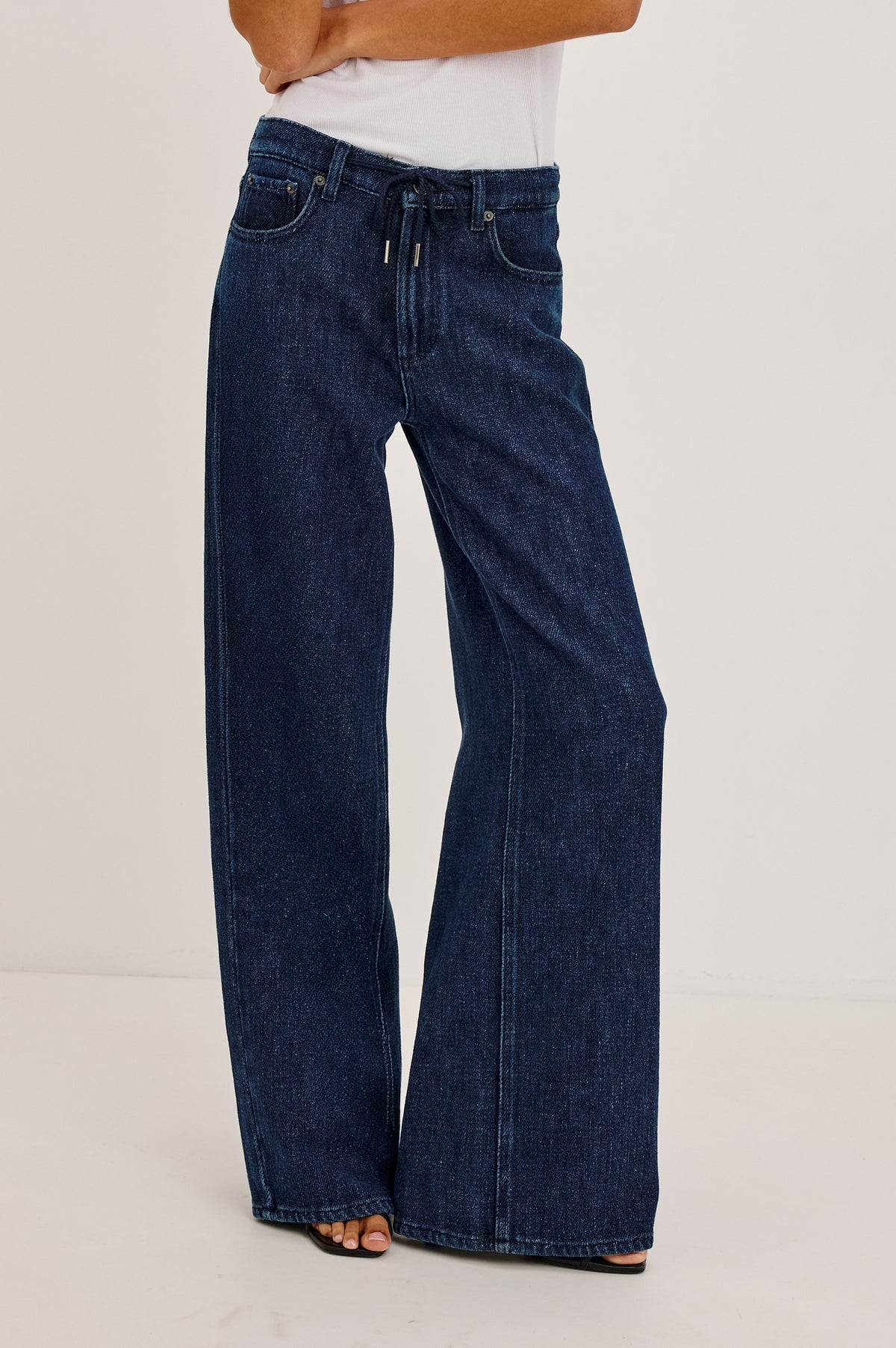Angeleno Wide Leg Jean With Mid-Rise Relaxed Fit, Wide Legs, Drawstring Waist Ties, Hidden Stretch, and 5-Pockets in Imperial Blue Colorway - Lower Body Front View Featured on Model