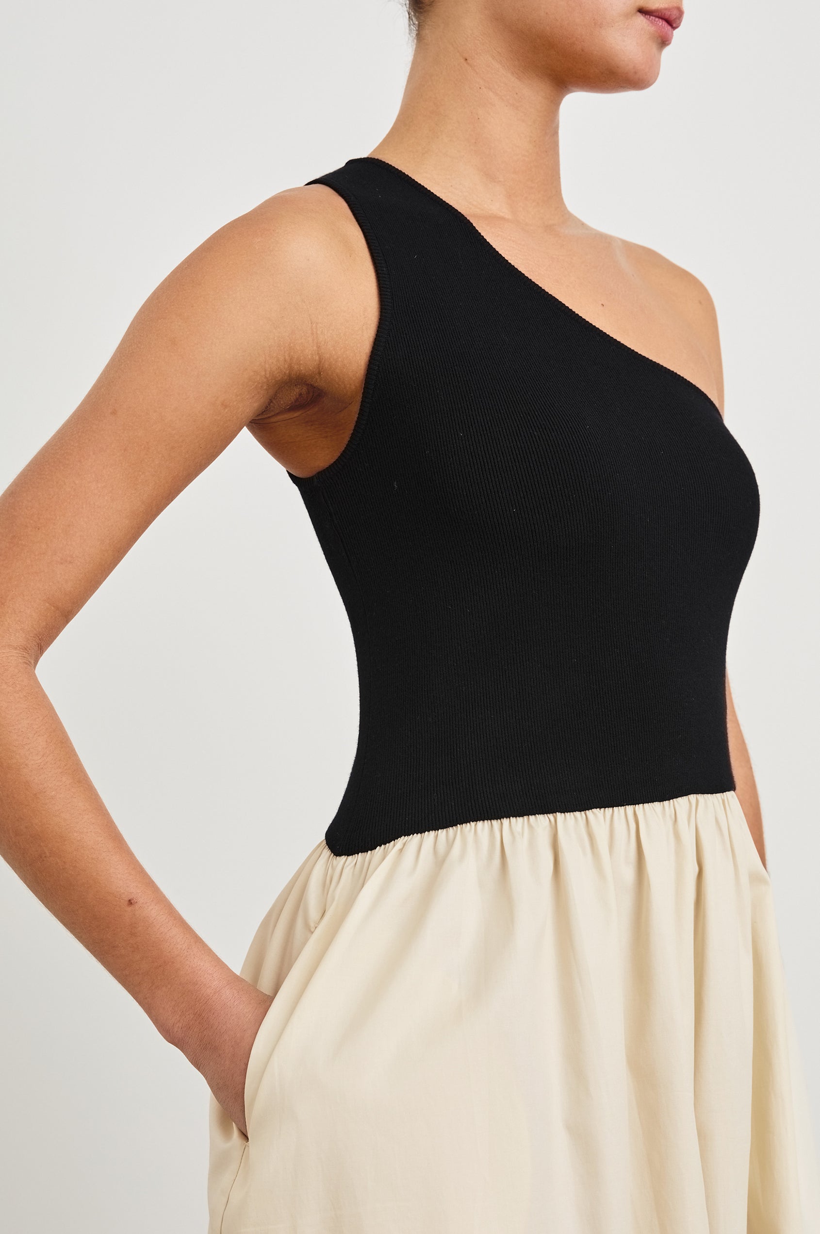 Anita Dress with Black asymmetrical bodice and ivory poplin midi skirt - close up of asymmetrical sleeve, on model