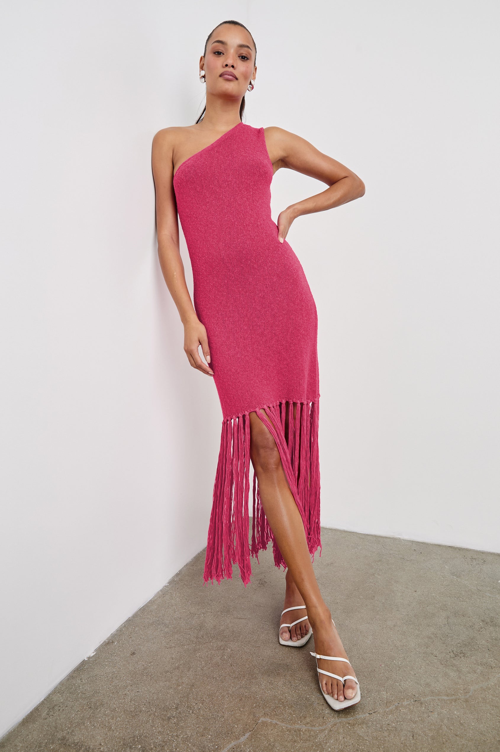 Antonia one shoulder midi length knit dress dress with knotted fringe at the bottom hemline in Raspberry colorway - full body front view on model