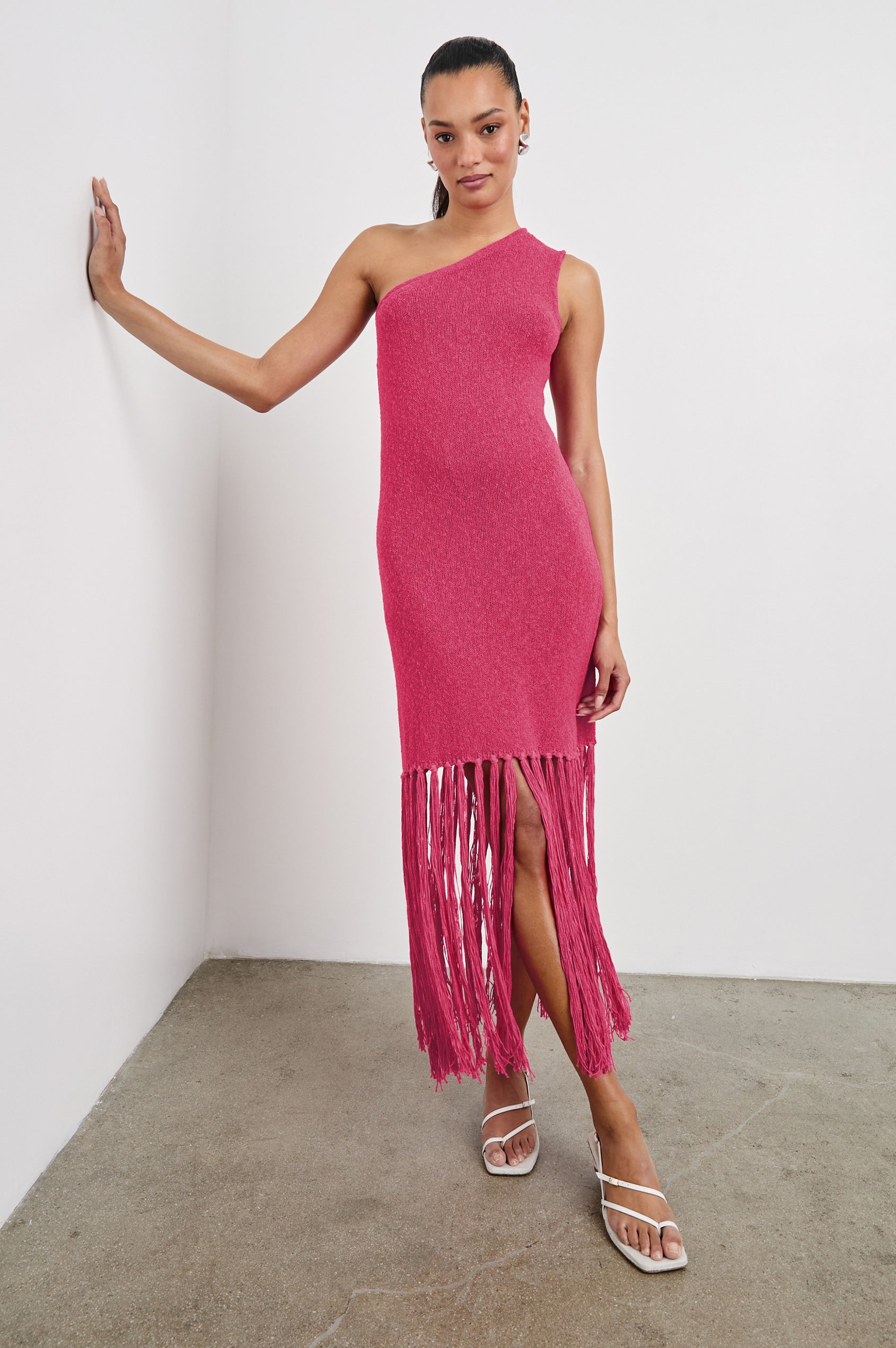 Antonia one shoulder midi length knit dress dress with knotted fringe at the bottom hemline in Raspberry colorway - full body front view on model