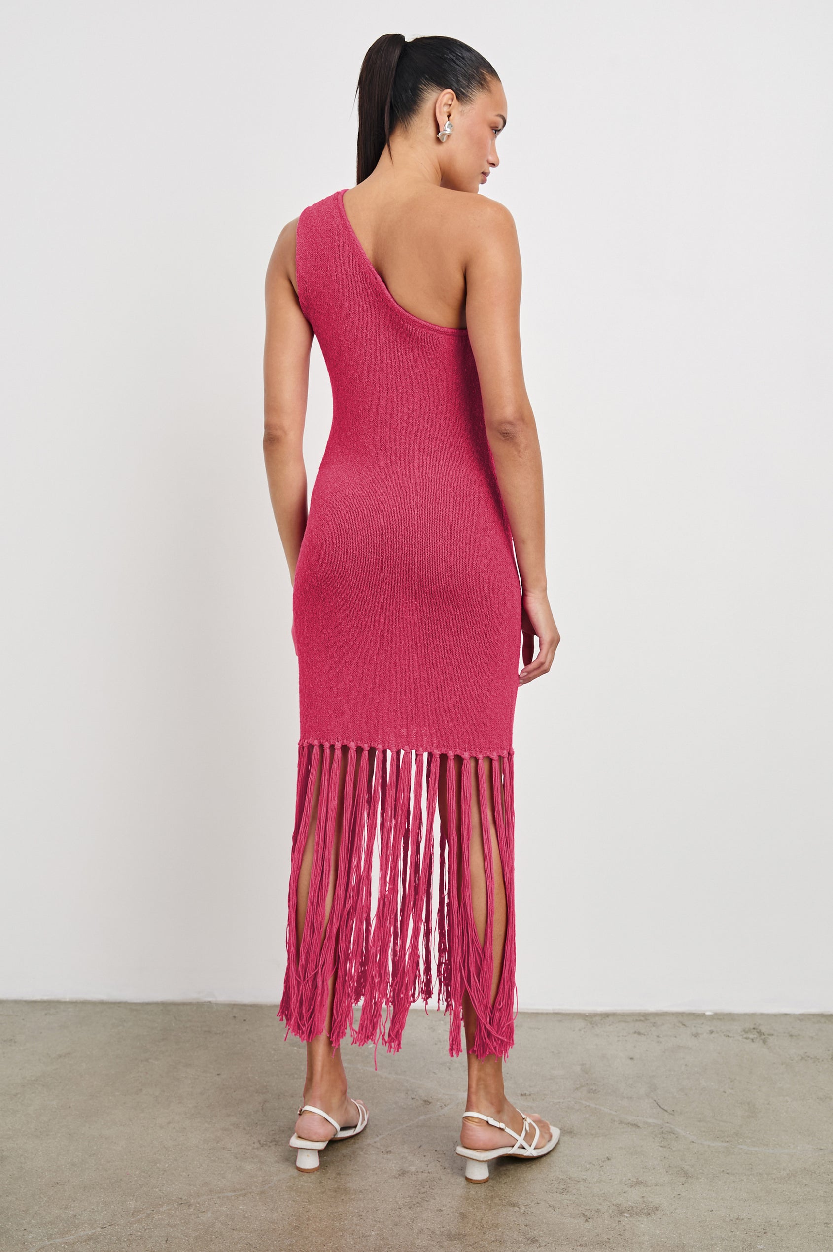 Antonia one shoulder midi length knit dress dress with knotted fringe at the bottom hemline in Raspberry colorway - back view on model