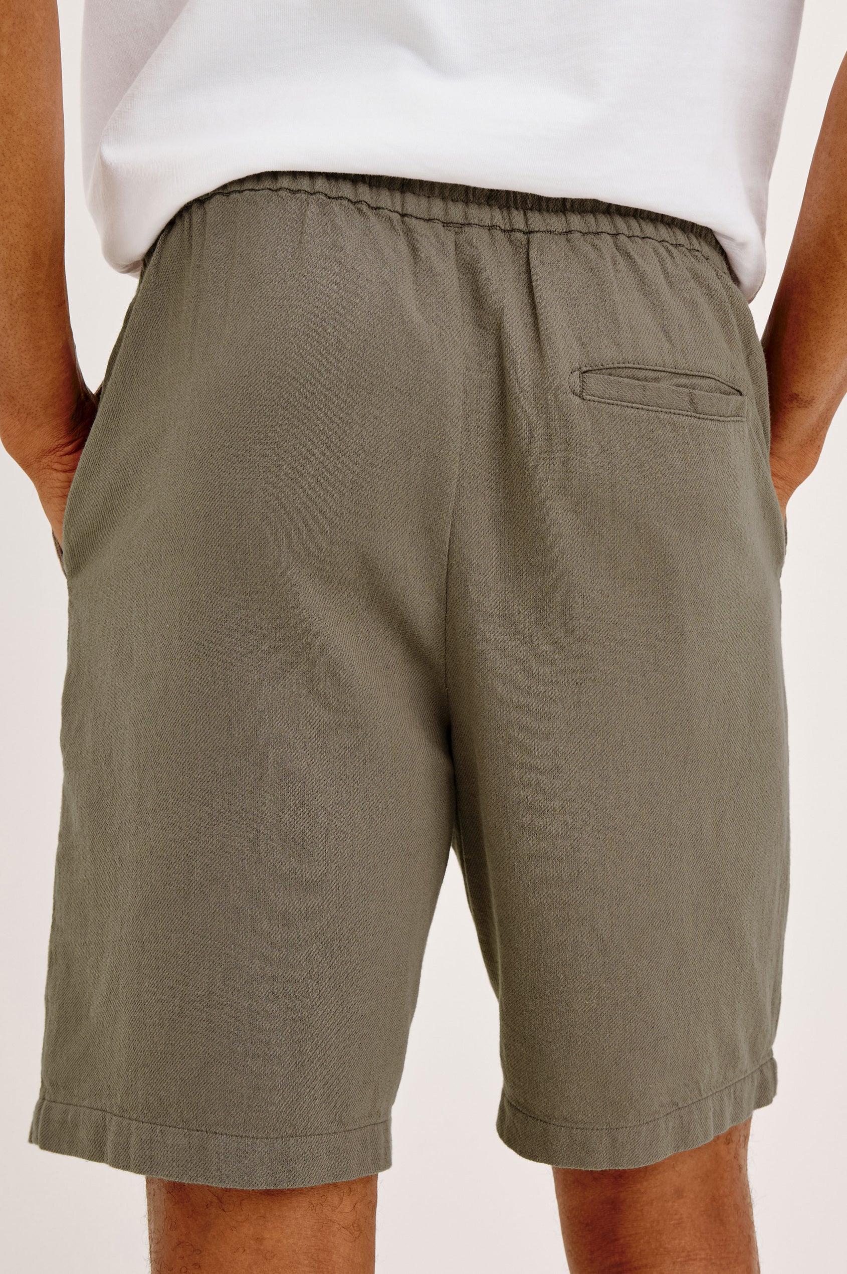 Archer Short in Unlined Cotton Linen With Relaxed Fit, Adjustable Waist Drawstring Ties, Side Pockts, and 8.5-Inch Inseam in Fallen Rock Colorway - Back View Featured on Model