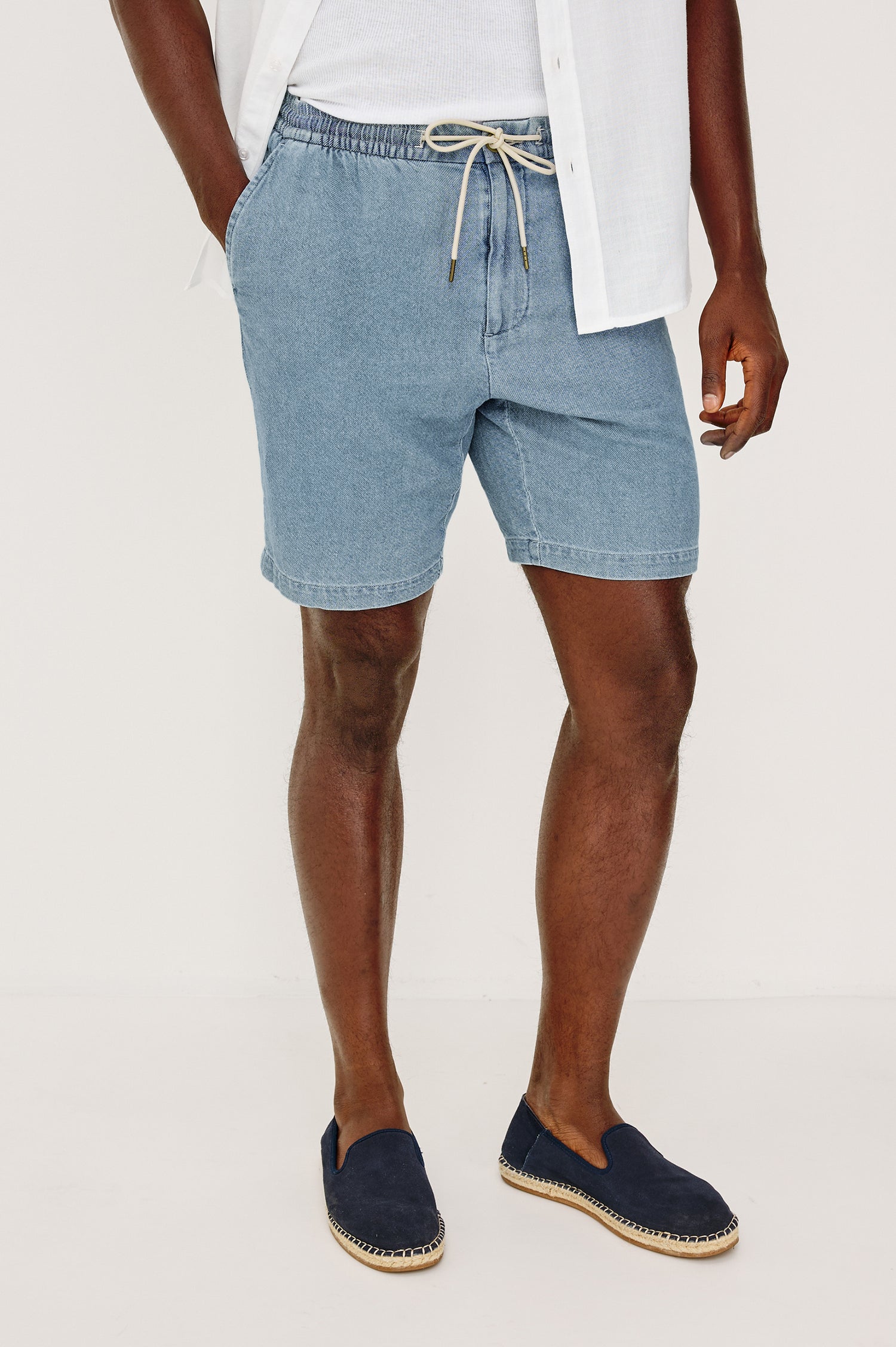 Archer Short in Unlined Cotton Linen With Relaxed Fit, Adjustable Waist Drawstring Ties, Side Pockts, and 8.5-Inch Inseam in Medium Wash Indigo Colorway - Front View Featured on Model