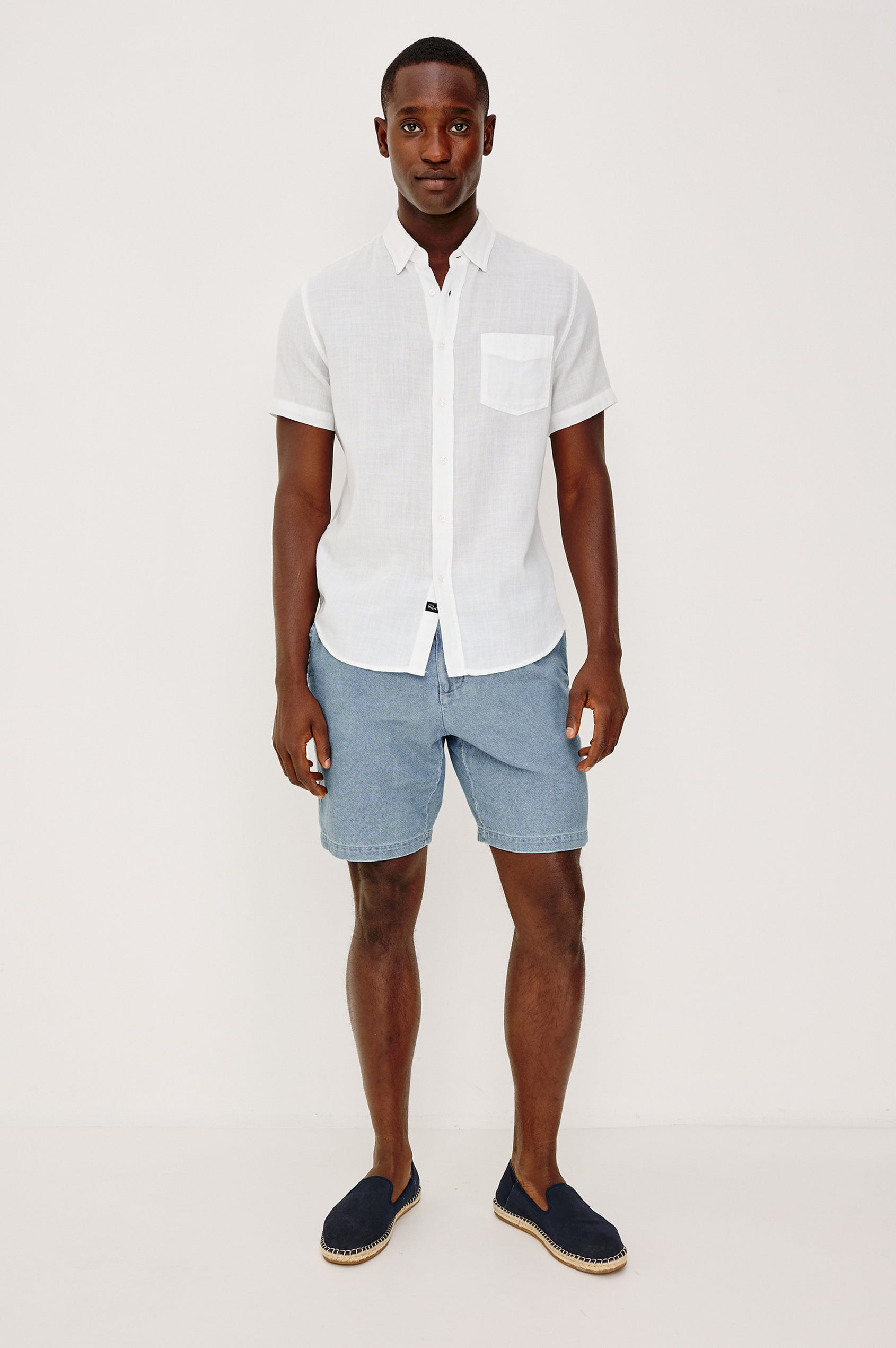 Archer Short in Unlined Cotton Linen With Relaxed Fit, Adjustable Waist Drawstring Ties, Side Pockts, and 8.5-Inch Inseam in Medium Wash Indigo Colorway - Full Body Front View Featured on Model