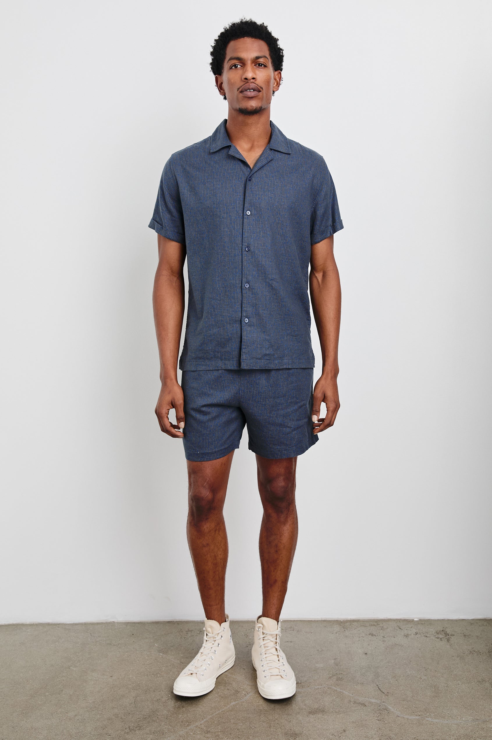 Aries Shorts with a Drawstring Waist, Two Front Pockets and a Buttoned Back Patch Pocket in Navy Cedar Vertical Colorway, with Thin Vertical Cedar Dashes on Navy - Front Full Body View Featured on Model