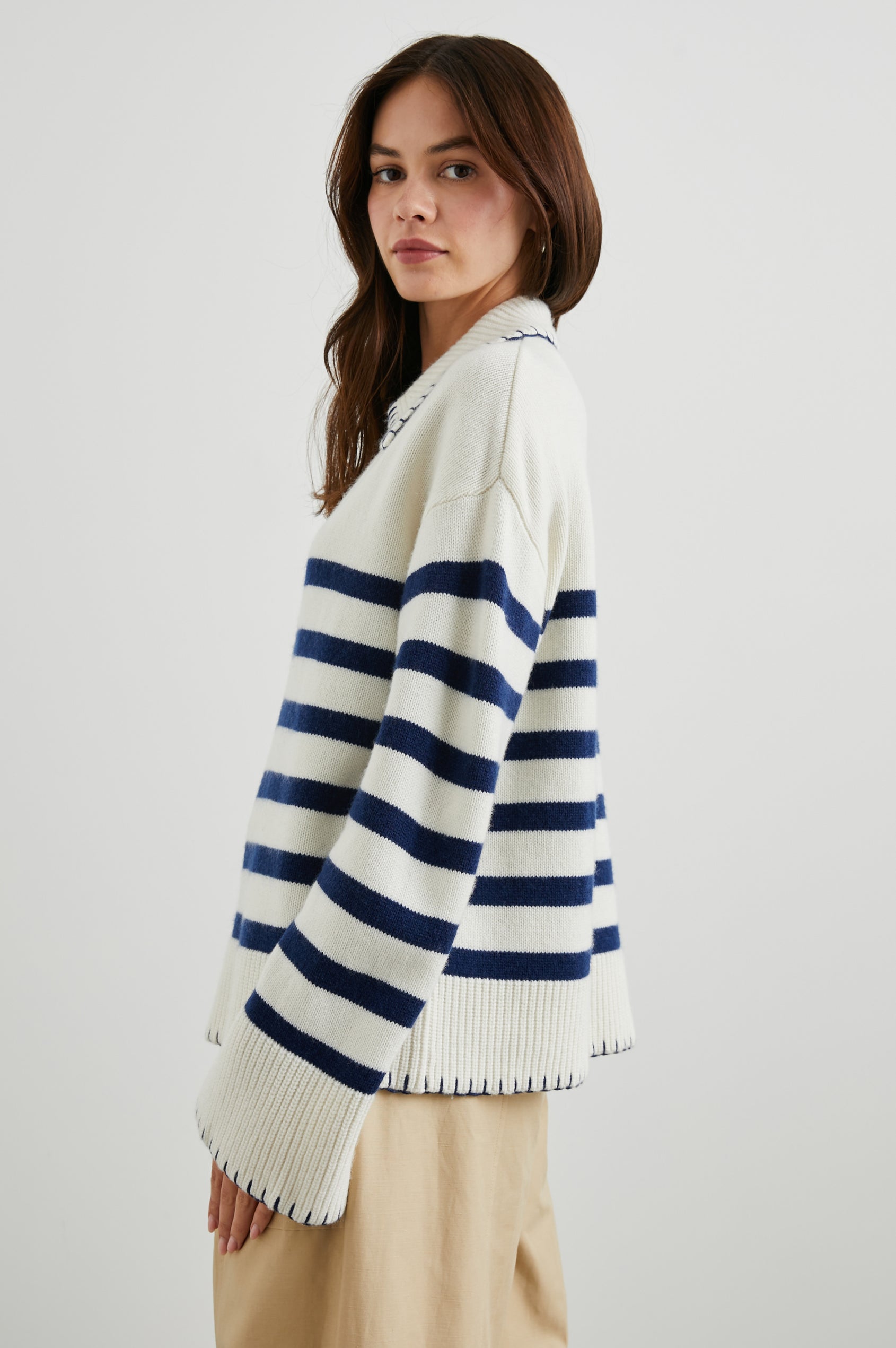 Athena Long-Sleeve Sweater with a Flat Collar V Neckline, Ribbed Cuffs and Hem and Contrast Stitching at the Cuffs and Hem in Ivory Navy Stripe Colorway, Horizontal Stripes - Side View Featured on Model 