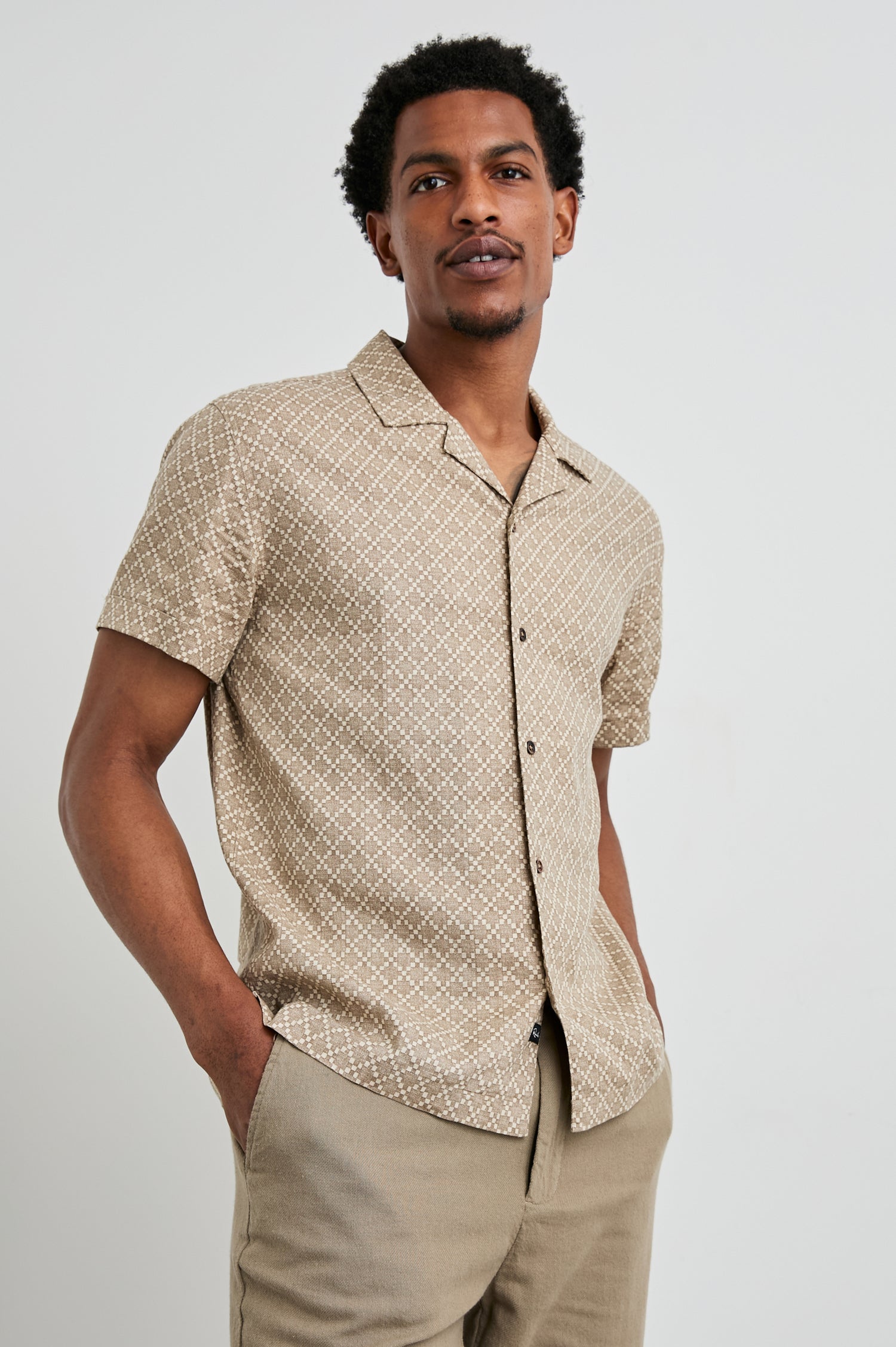 Atlas Short-Sleeve Button Up in Ikat Oat Colorway, with a diamond pattern in browns - Front View Featured on Model