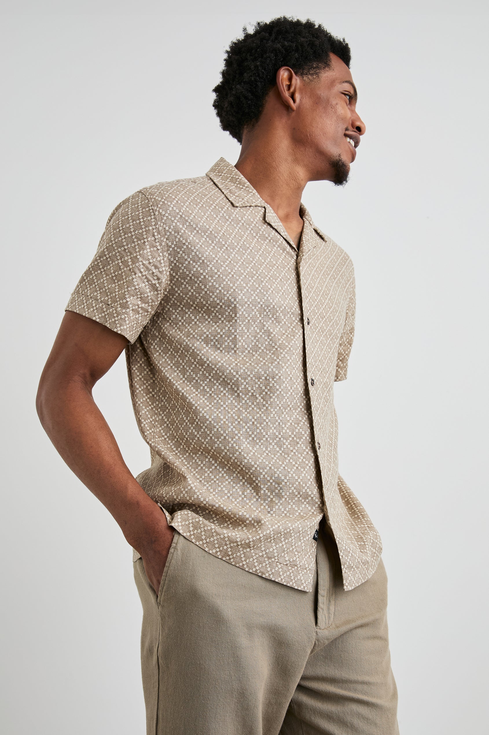 Atlas Short-Sleeve Button Up in Ikat Oat Colorway, with a diamond pattern in browns - Front View Featured on Model