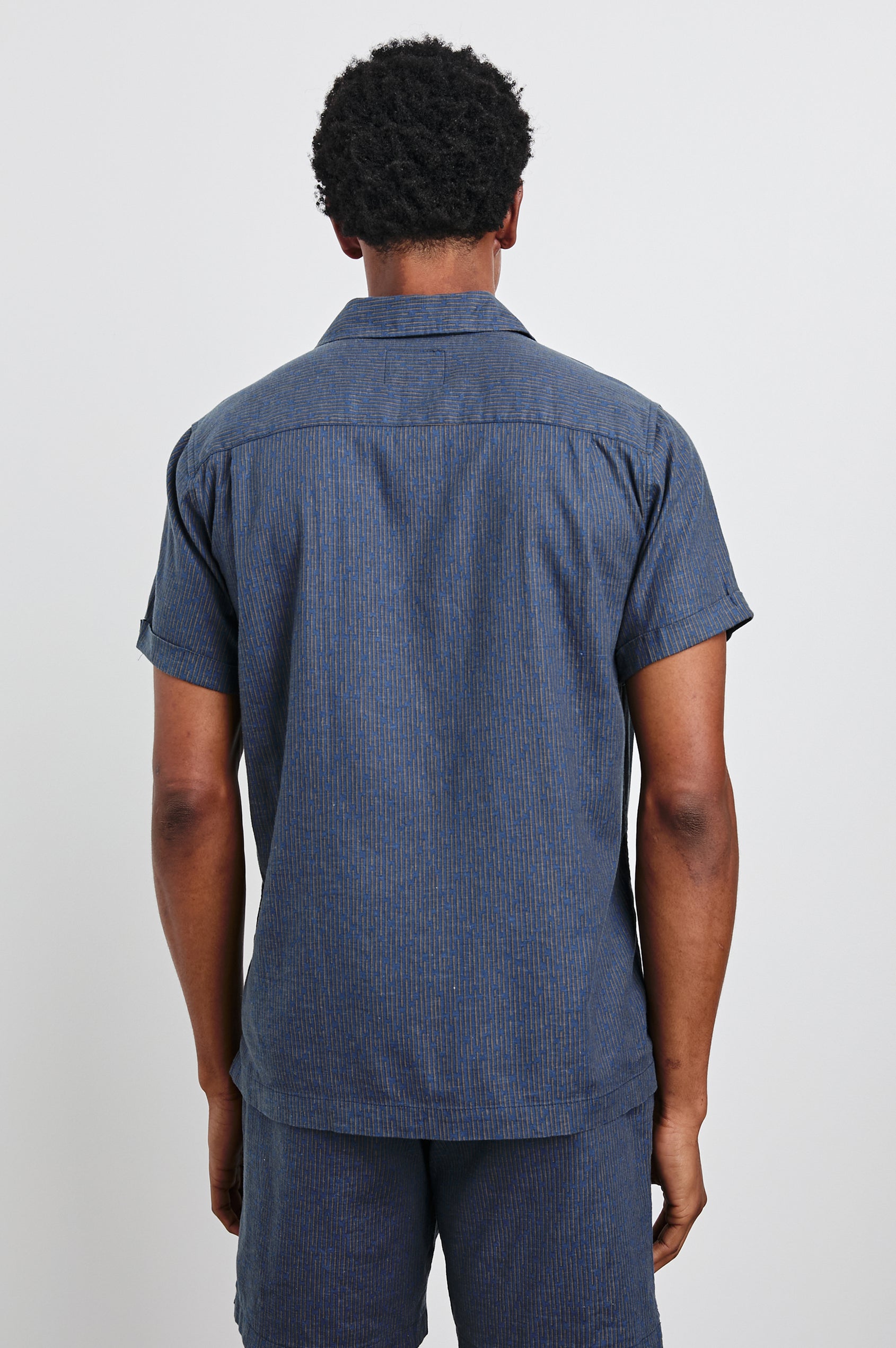 Atlas Short-Sleeve Button Up in Navy Cedar Vertical Colorway, with Thin Vertical Cedar Dashes on Navy - Back View Featured on Model