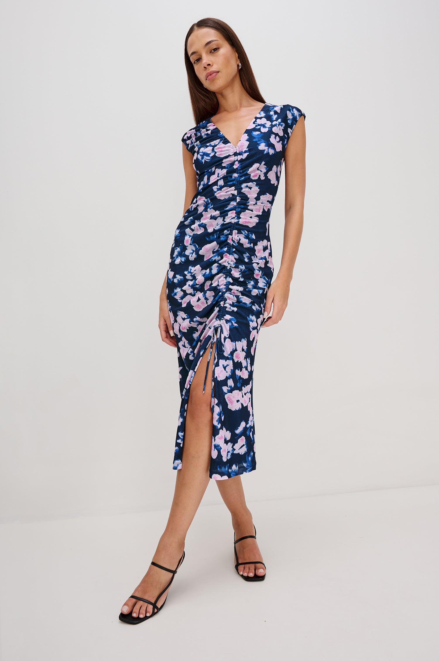 Auren Midi Dress with Cap Sleeves, a Deep V Neck, a Mid-Thigh Side Slit and Ruching from the V Neck to the Slit with a Drawcord at the Slit in Midnight Peony Colorway - Front Full Body View Featured on Model 