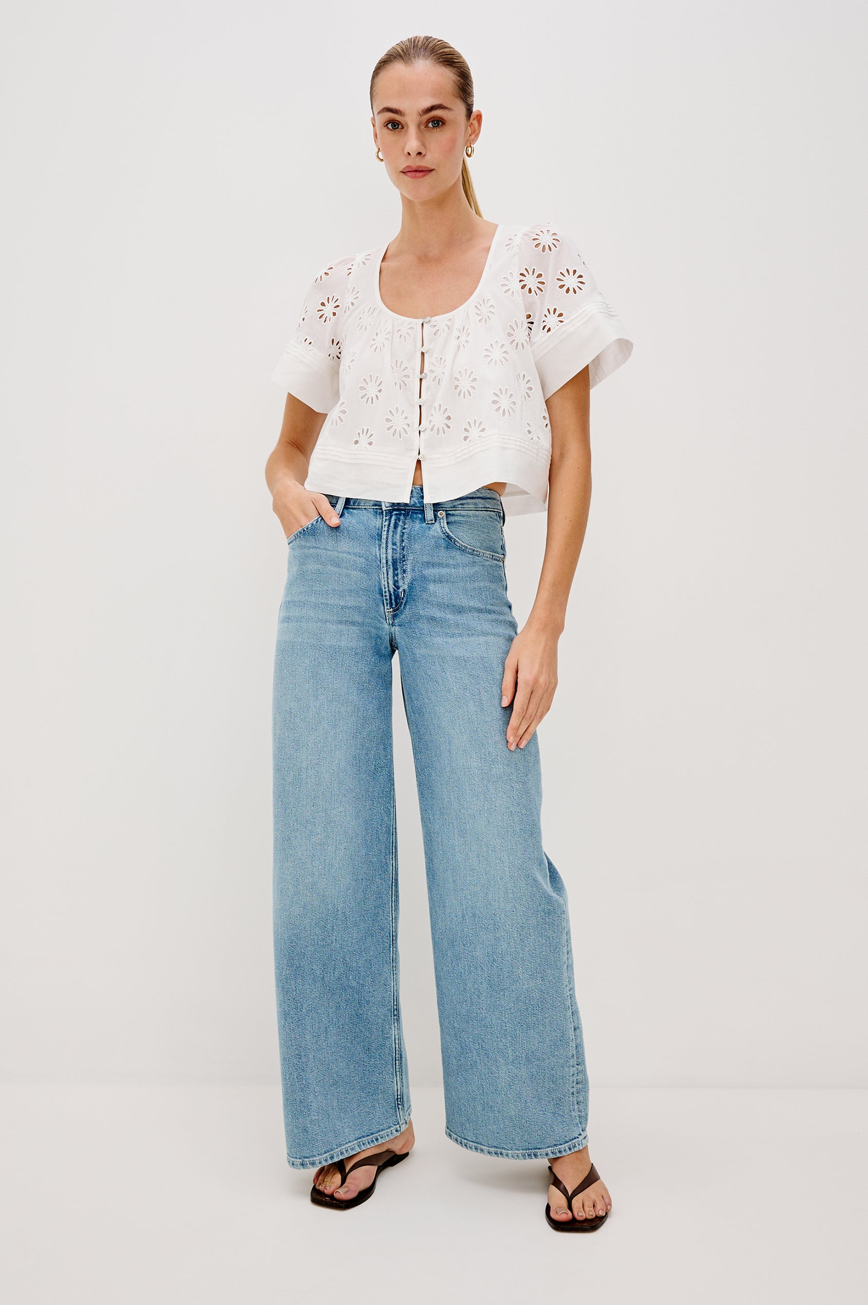 Bambina scoop neck top with short sleeves, button front, baby doll shape with cutout flowers through out in White colorway. Full Body Front View Shown on Model.