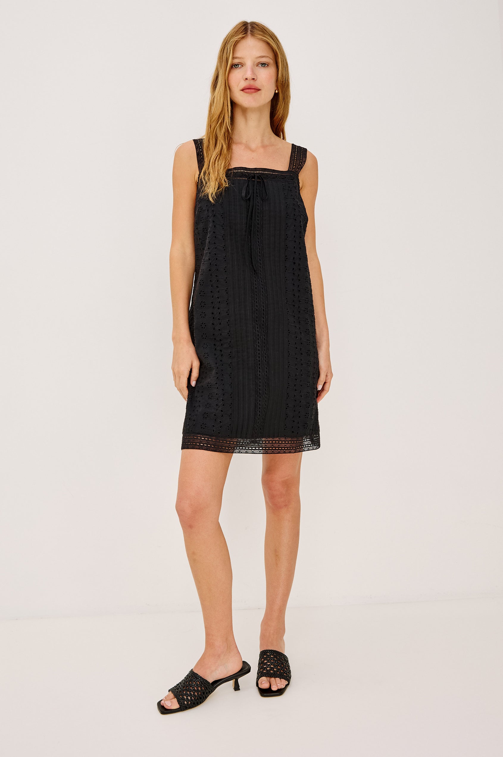 Beckton Mini Shirt Dress With Square Neckline, Eyelet Embroidery, Front Pintucks, Center-Front Ties, and Lace Shoulder Straps in Black Colorway - Full Body Front View Featured on Model