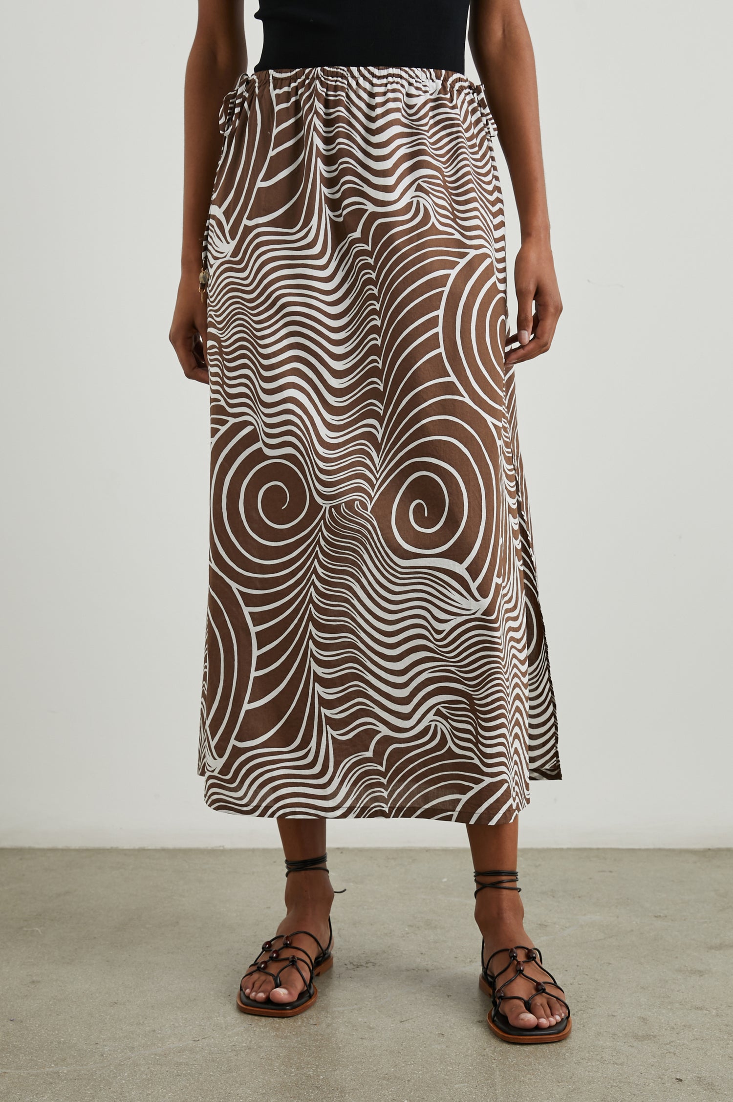 Beech Midi Skirt with a Side Drawstring Waist in Swirls Colorway, White Waves and Swirls on Brown - Front View Featured on Model 