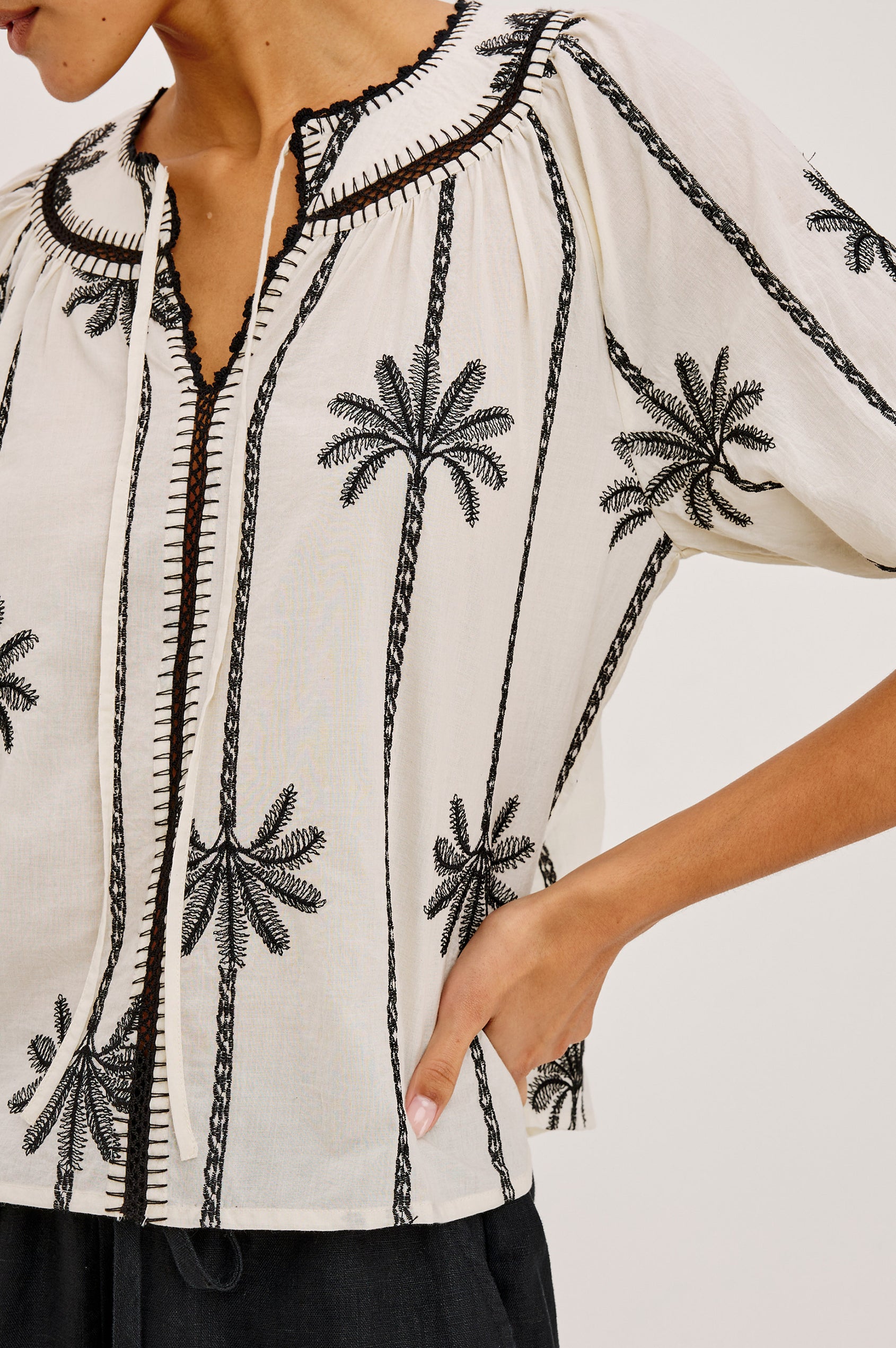 Belina Peasant Top in Cotton Voile With Gathered V-Neckline With Self Ties, Loose Fit, and Elbow-Length Puff Sleeves With Elastic Cuffs in Embroidered Palms Colorway - Upper Body Front View Featured on Model