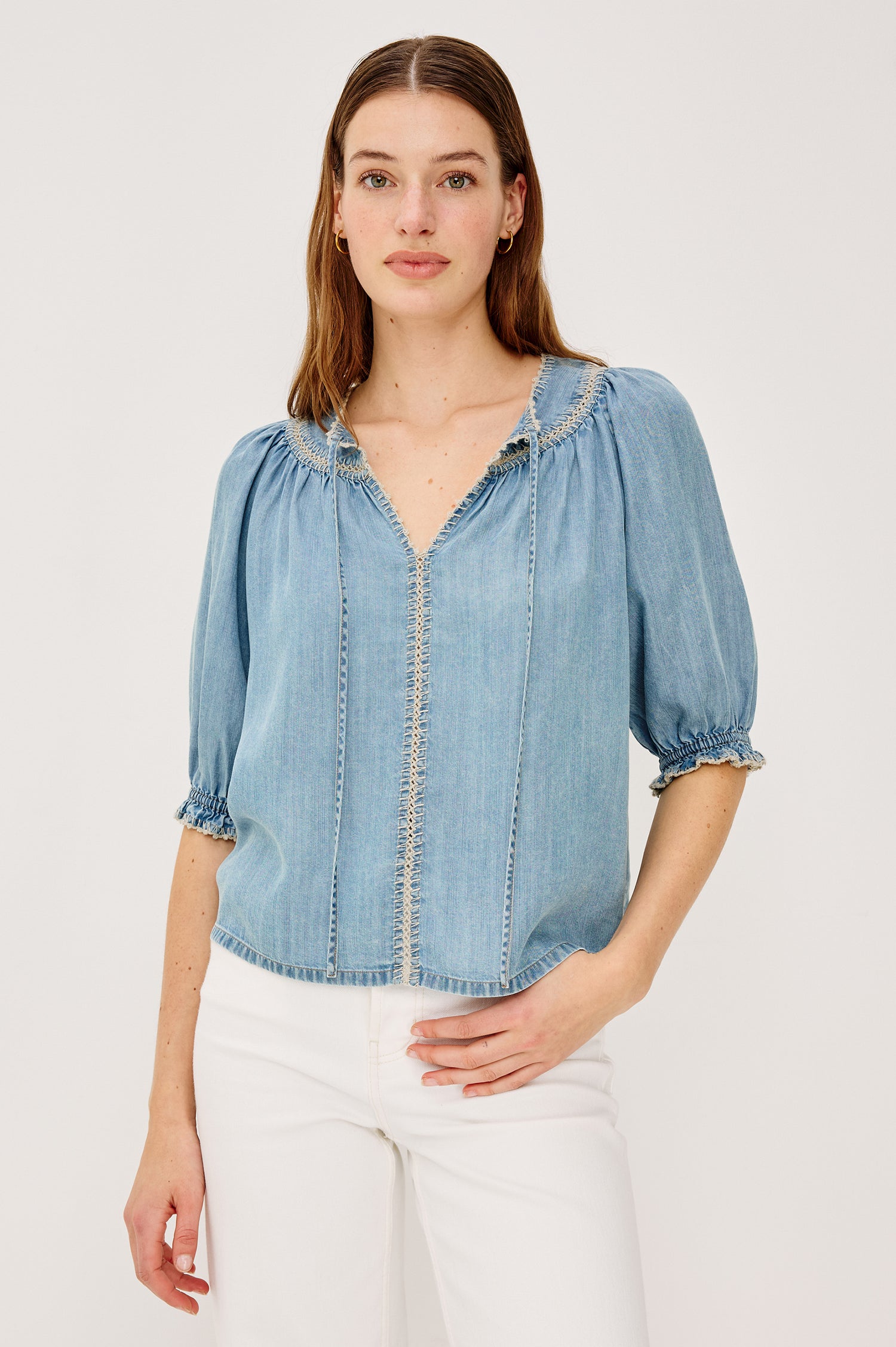 Belina Peasant Top in TENCELâ„¢ Denim With Gathered V-Neckline With Self Ties Blanket Stitch Embroidered Trim Loose Fit and Elbow-Length Puff Sleeves With Elastic Cuffs - Upper Body Front View Featured on Model
