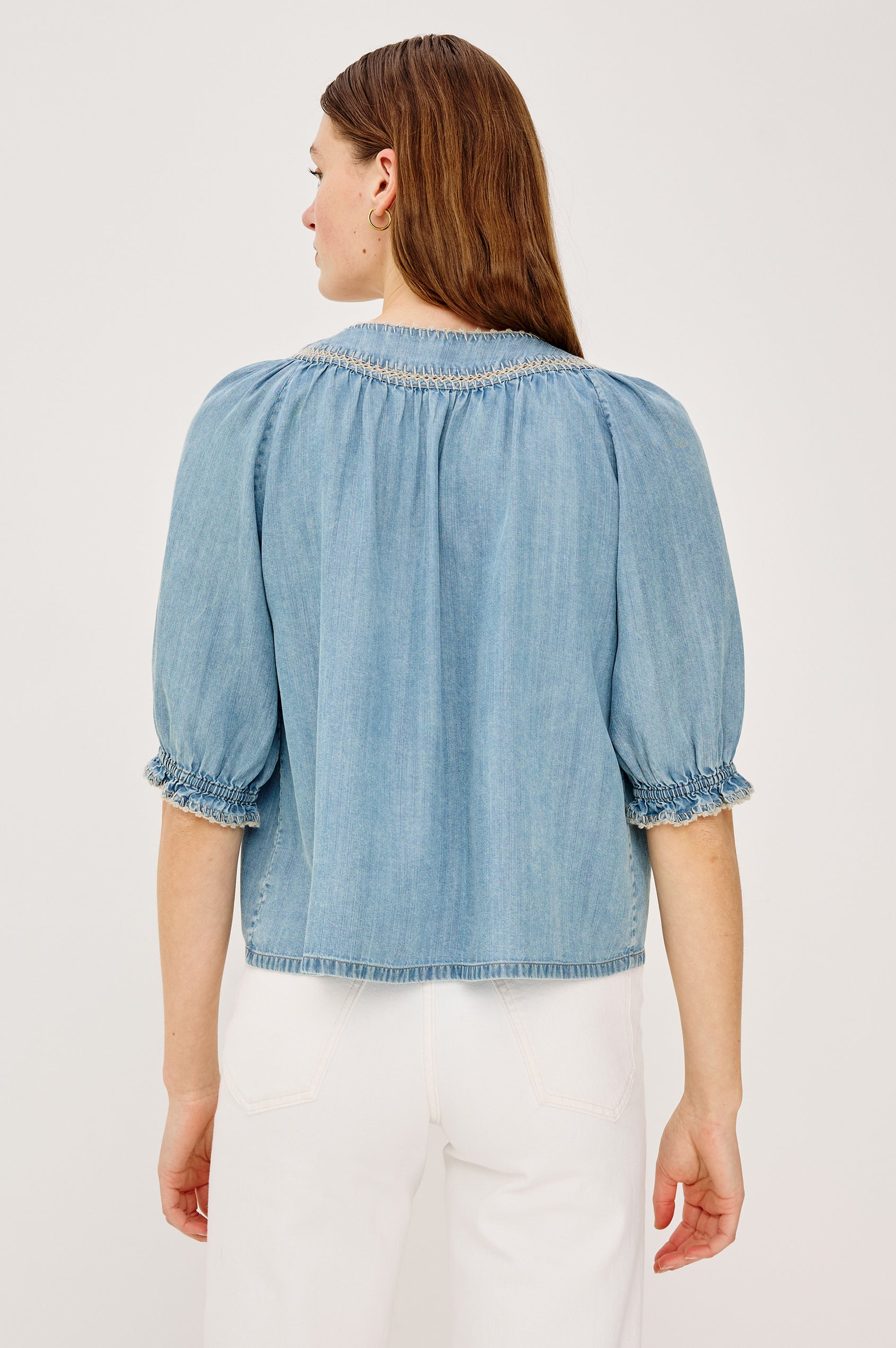 Belina Peasant Top in TENCELâ„¢ Denim With Gathered V-Neckline With Self Ties Blanket Stitch Embroidered Trim Loose Fit and Elbow-Length Puff Sleeves With Elastic Cuffs - Upper Body Back View Featured on Model