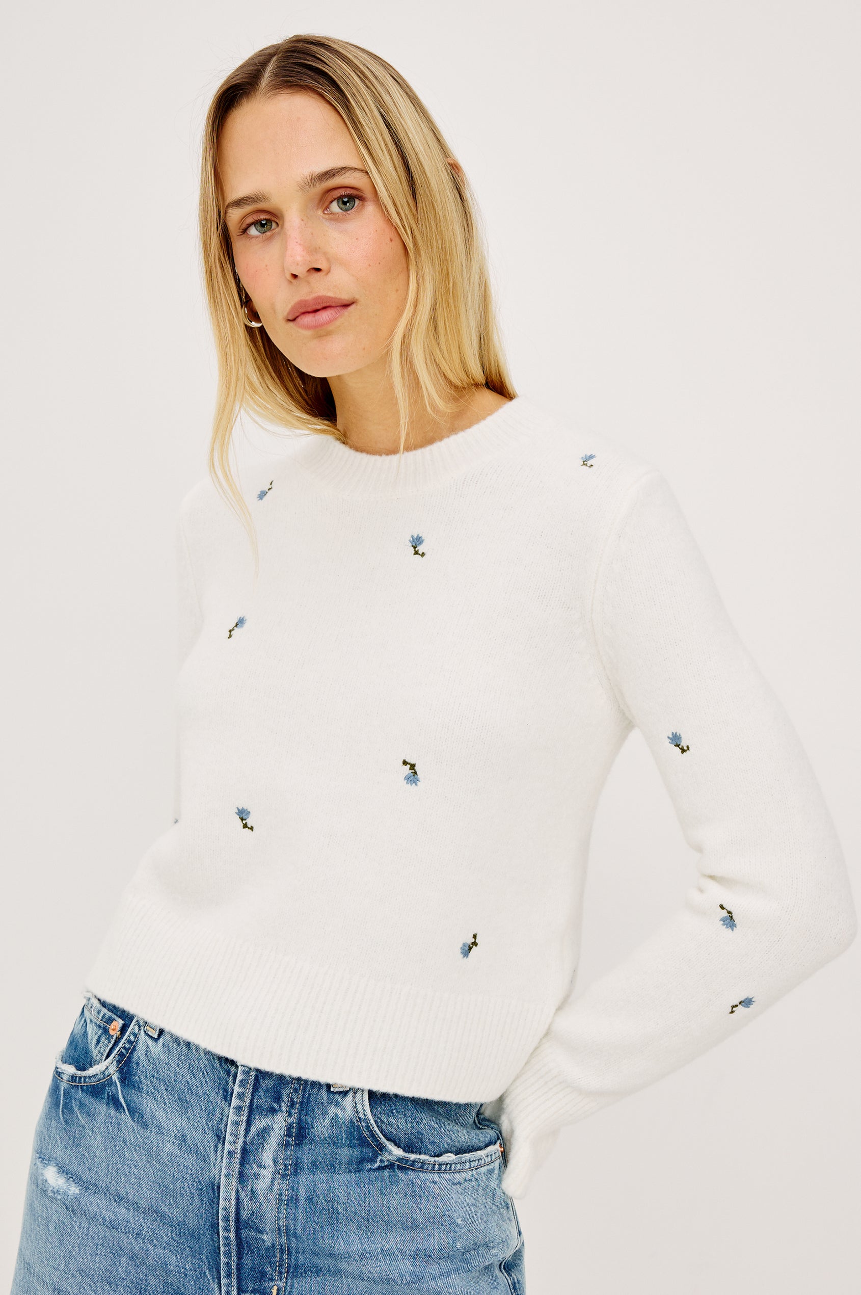 Bettie Sweater in Soft Wool Blend With Crew Neck, Long Sleeves With Ruffled Cuffs, Ribbed Trim, and Floral Embroidery in Blue Buds Colorway - Upper Body Front View Featured on Model
